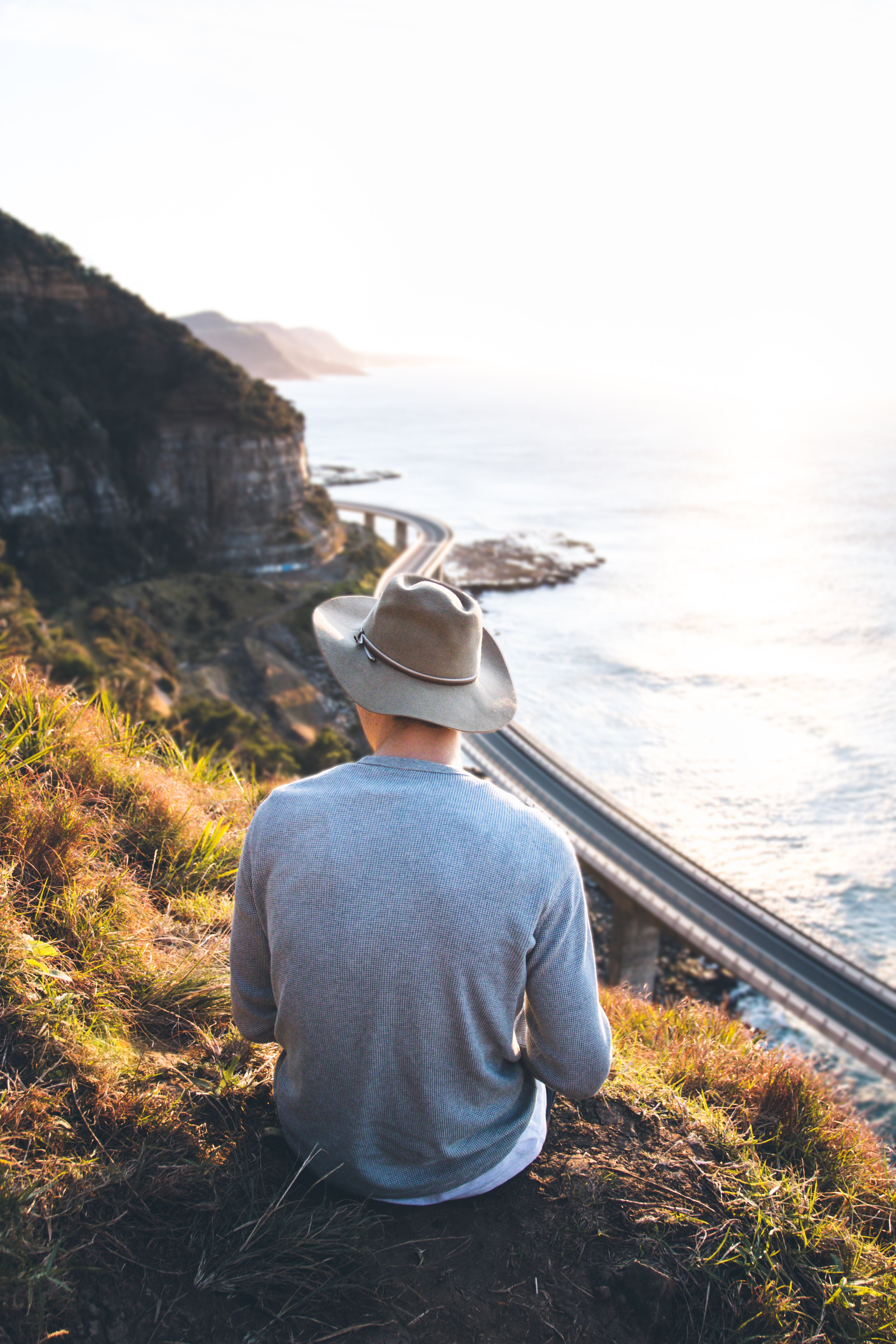 looking at view, one person, clothing, road, solo, hat, men, leisure activity, cliff, beauty in nature, person, water, travel, ocean, scenics - nature, Phone HD Wallpaper