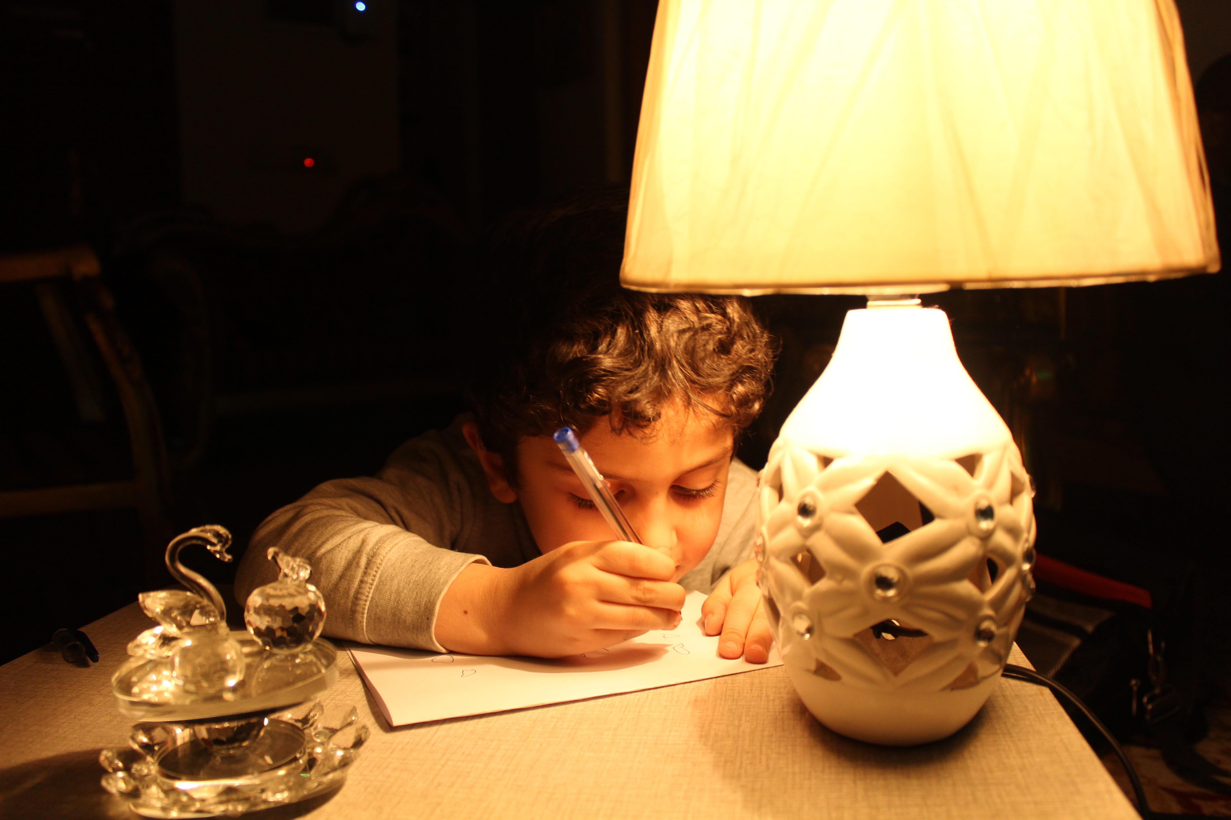 illuminated, boys, light, offspring, sitting, table, kid, headshot, males, iraq, baghdad, 5K, learning, men, electric lamp, dark, glass, indoors, innocence, HD Wallpaper