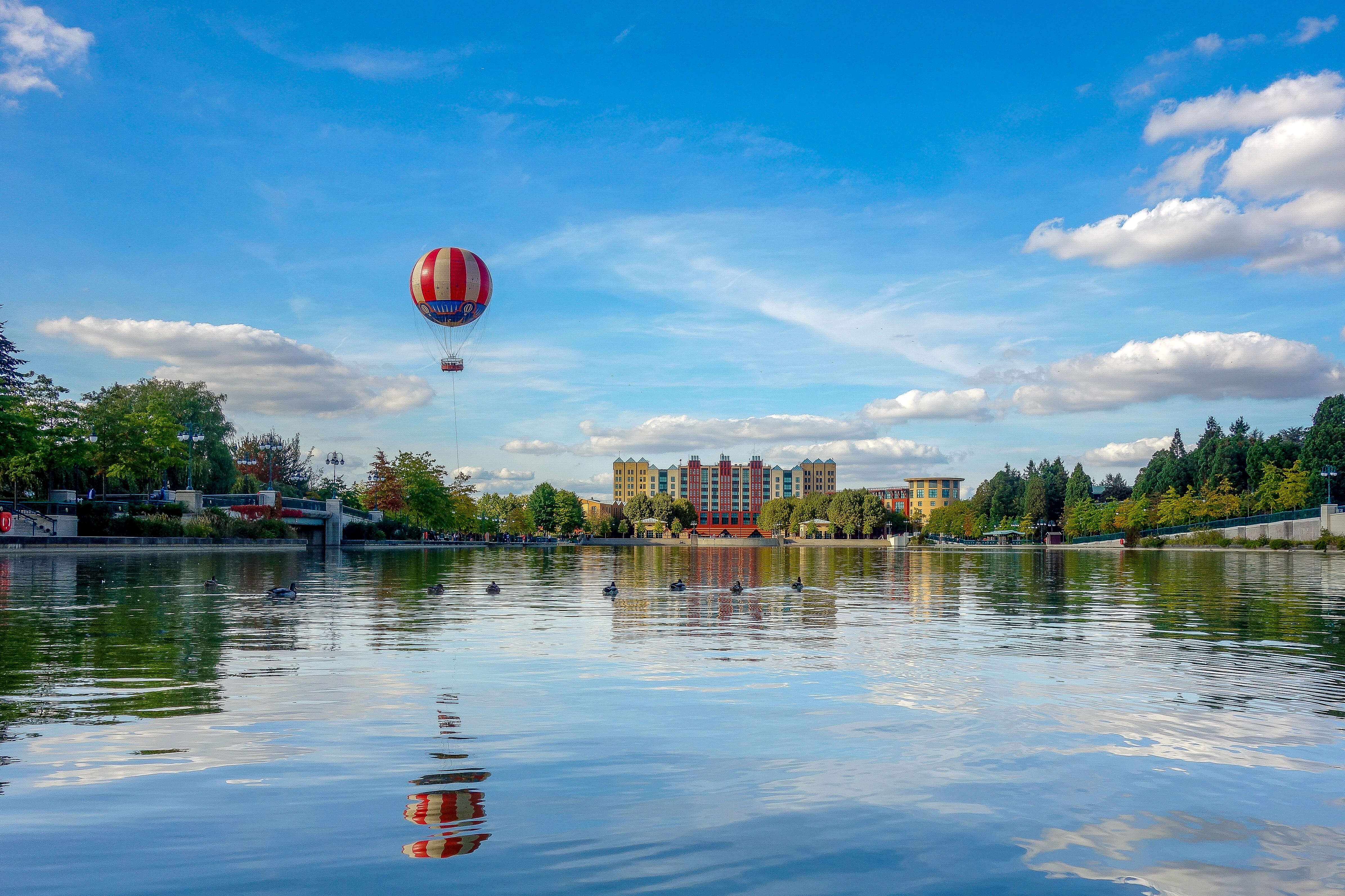 water, holiday, leisure, nature, mid-air, sky, day, 4K, tranquility, hot-air ballooning, disney, reflection, waterfront, tree, no people, outdoors, adventure, HD Wallpaper