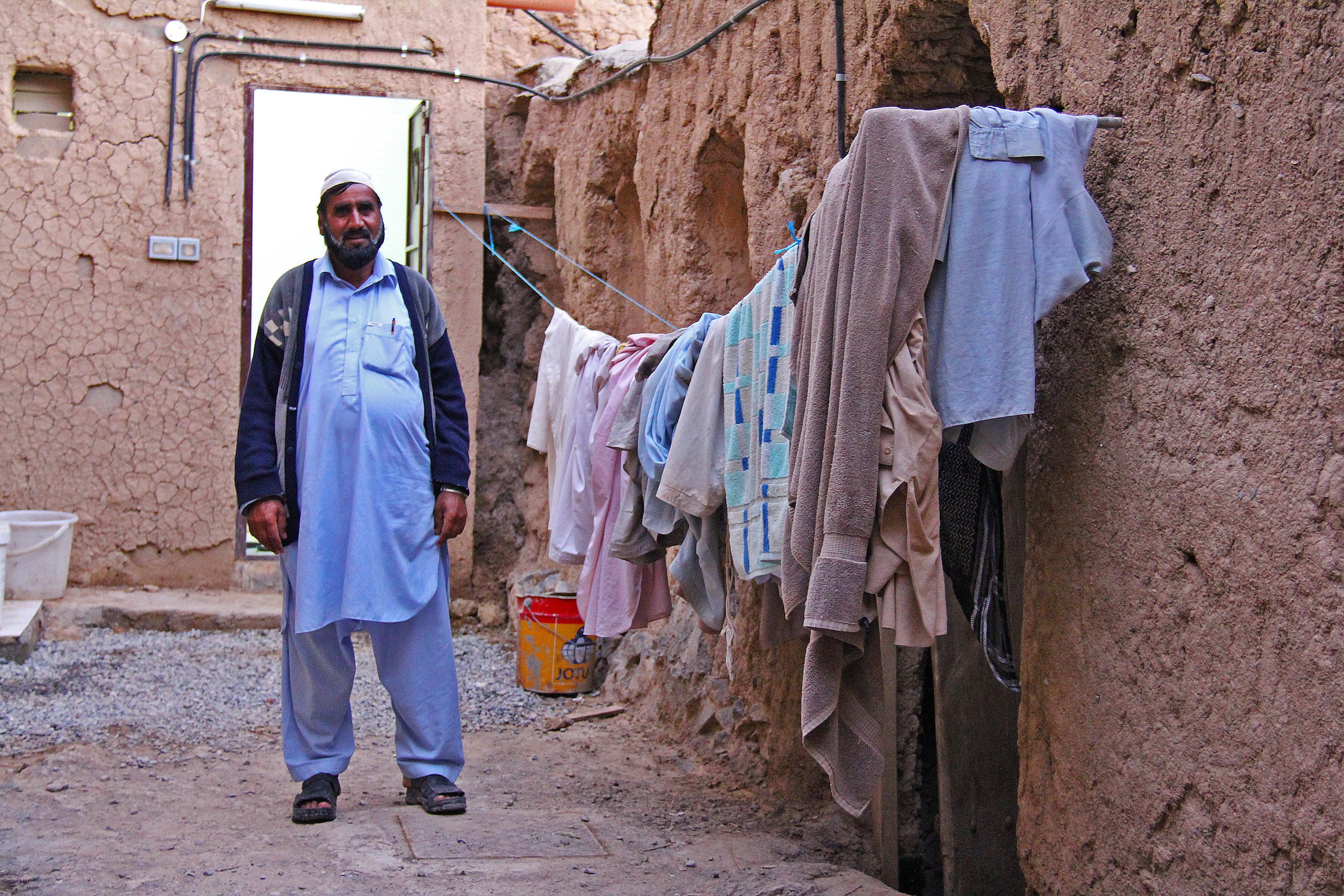 front view, clothing, architecture, people, one person, hanging, tourism, 400-year, al hamra, historic, day, travel, wall, alley, street, stone wall, 2K, HD Wallpaper