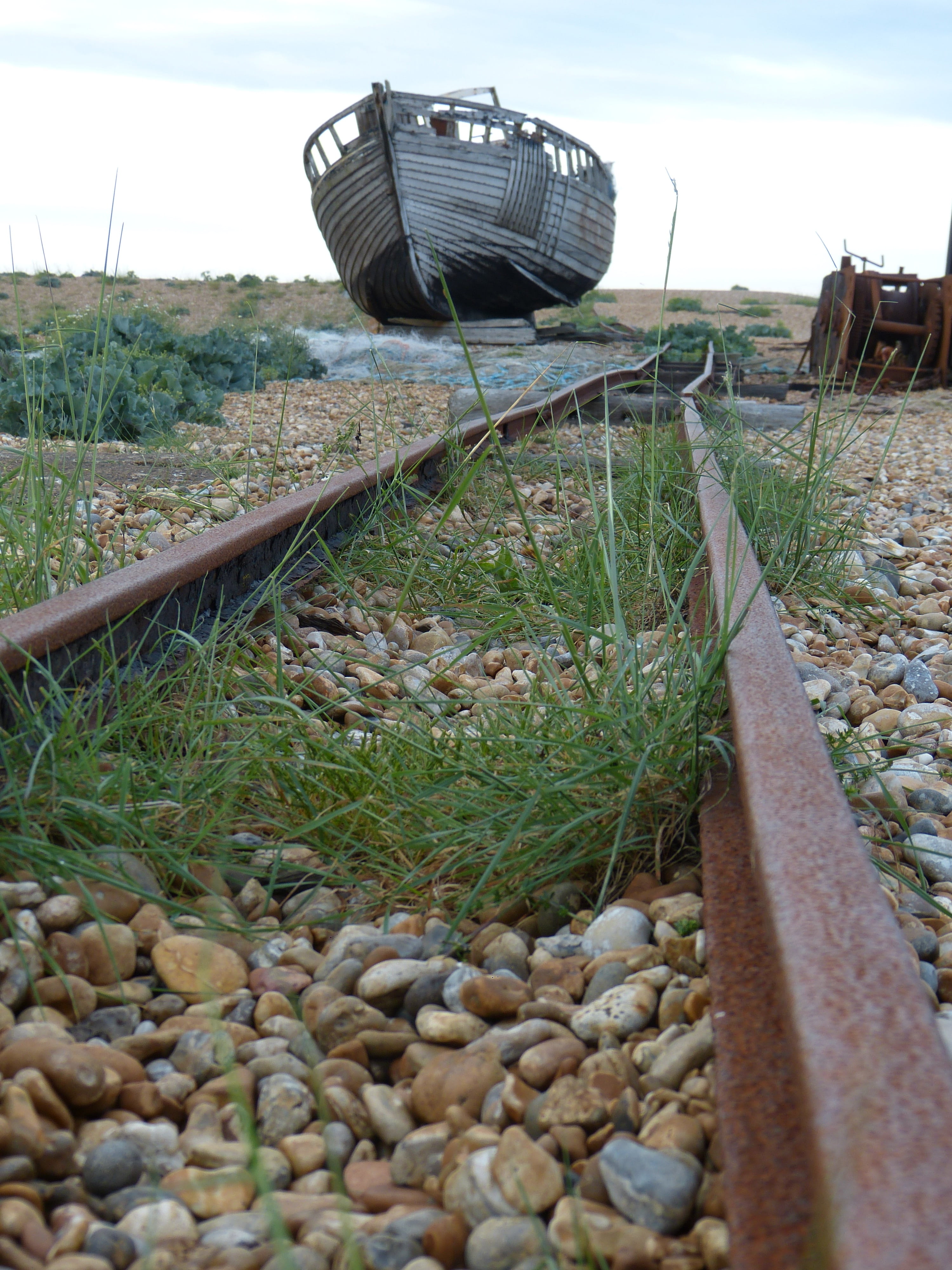 rusted, metal, track, grass, sky, field, wreck, fishing net, day, railroad track, dungeness, ship, no people, england, kent, outdoors, architecture, seemed, Phone HD Wallpaper
