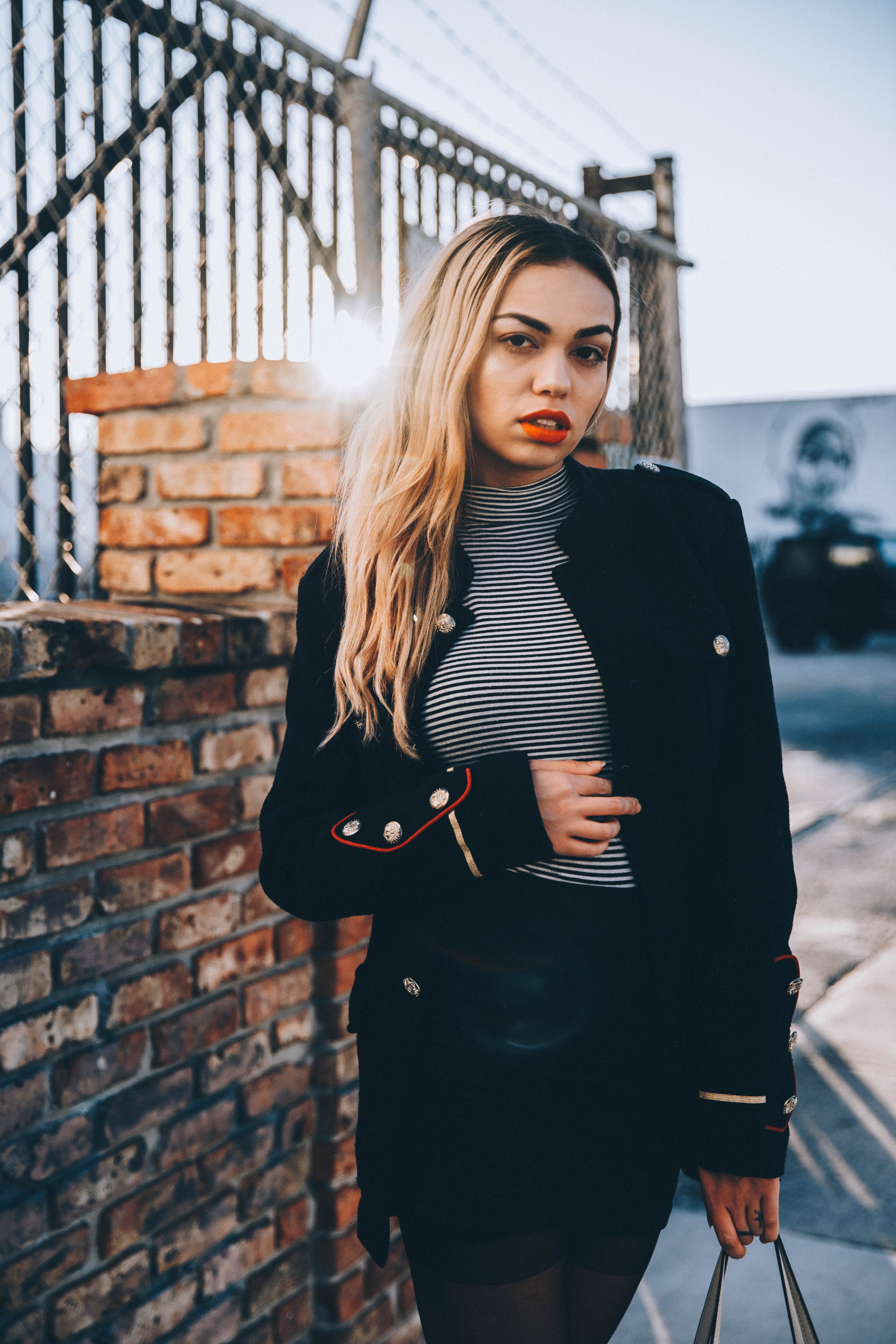 brick, focus on foreground, stomach, standing, brown, hair, outdoors, fence, cladding, fashion, front view, adult, young adult, long hair, bag, portrait, Phone HD Wallpaper