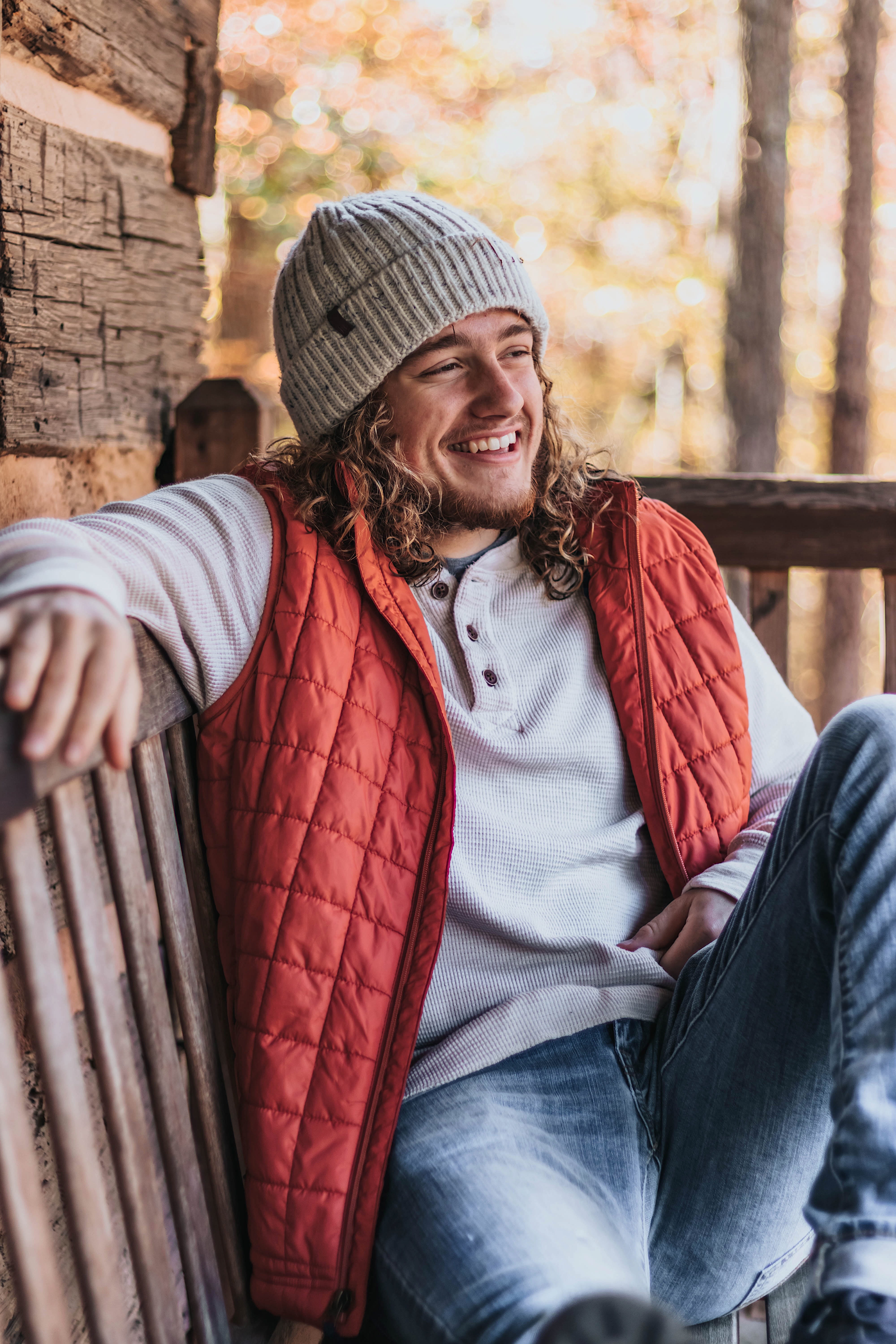 person, fall, smiling, apparel, denim, chair, young adult, furniture, one person, cap, sweater, sitting, clothing, hat, happiness, 5K, wood, lifestyles, Phone HD Wallpaper
