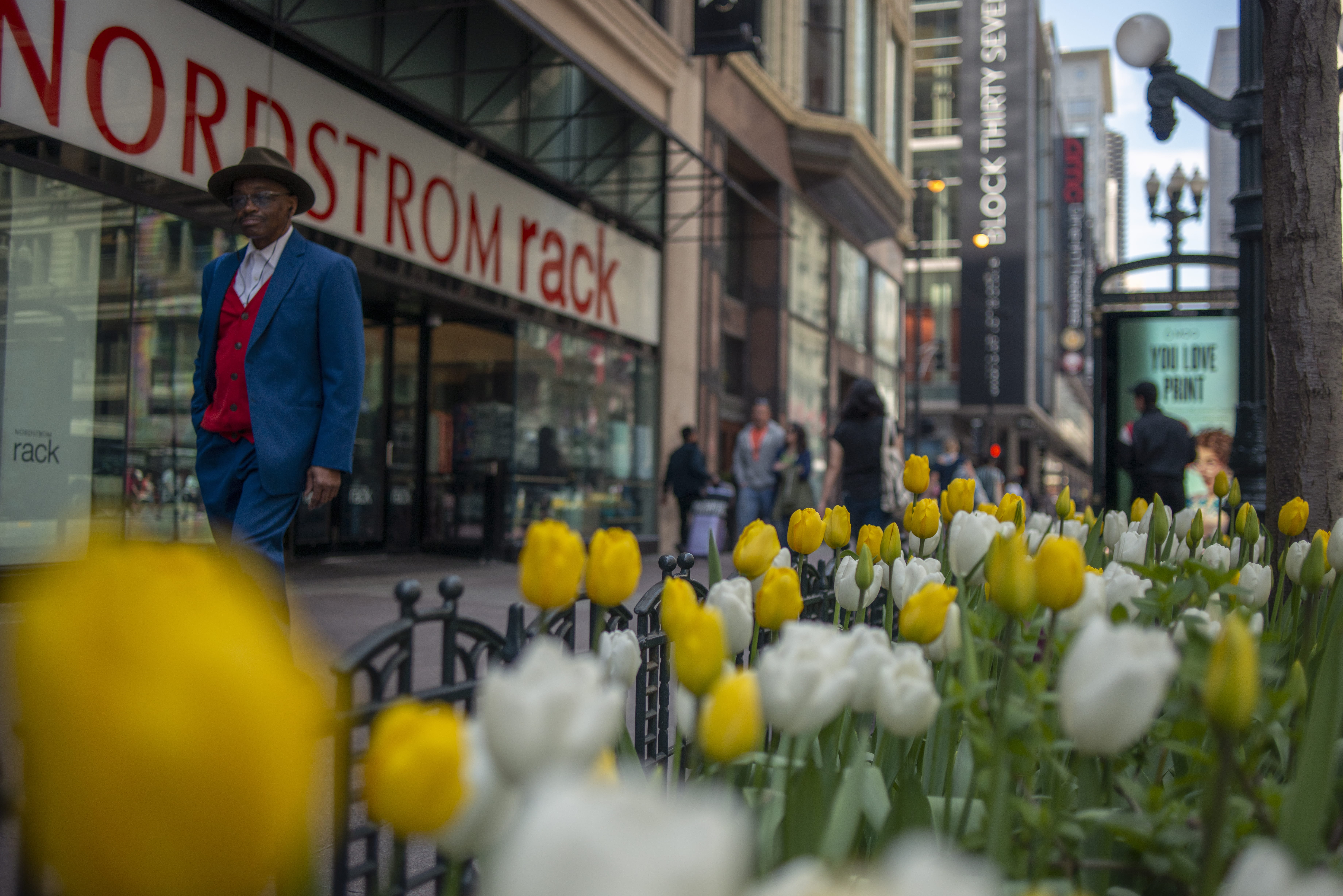 flower, street photography, person, selective focus, western script, built structure, plant, overcoat, apparel, standing, day, town, men, city life, suit, HD Wallpaper