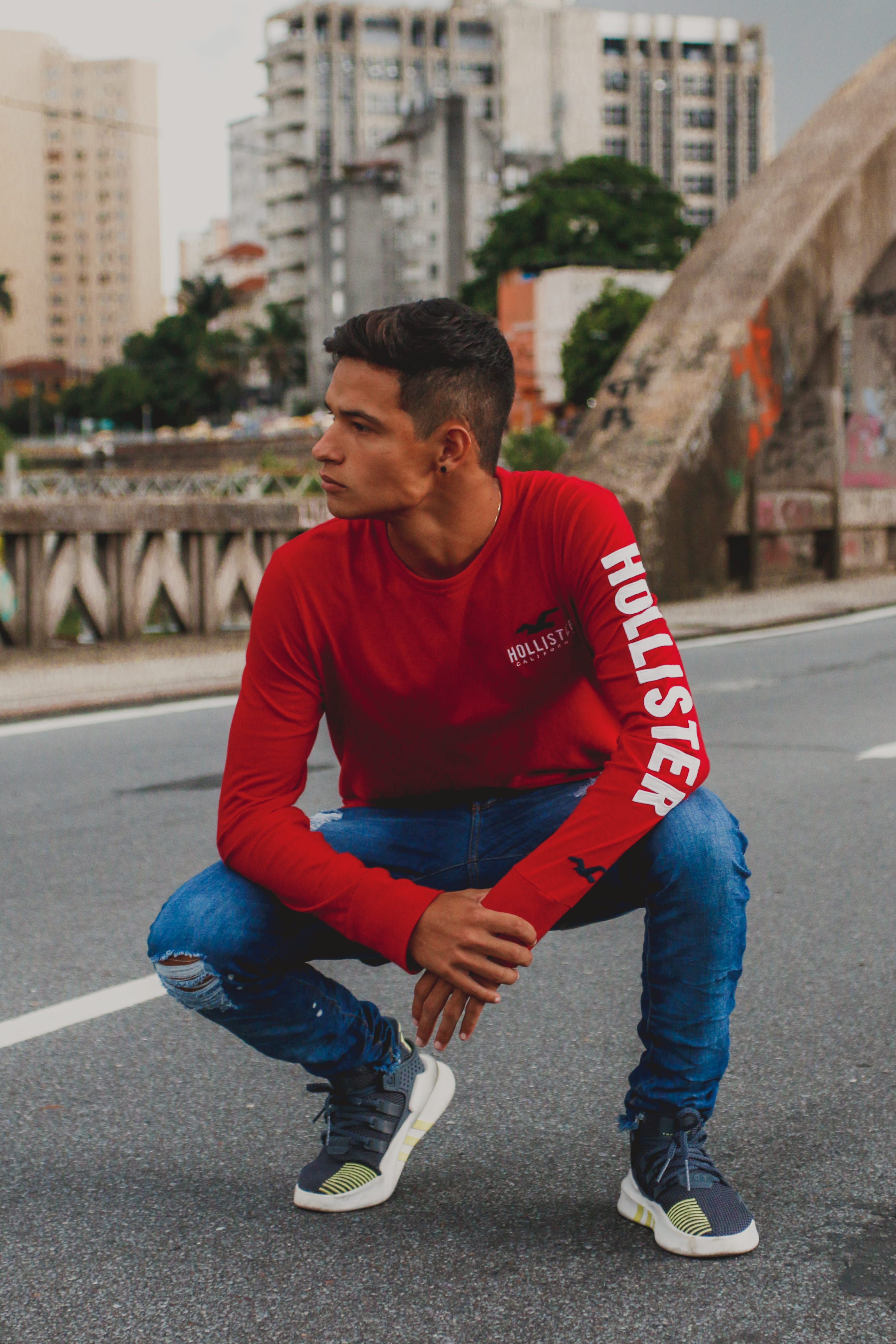 outdoors, casual clothing, real people, day, focus on foreground, shoes, posture, 4K, trendy, one person, sitting, front view, sneakers, building exterior, Phone HD Wallpaper