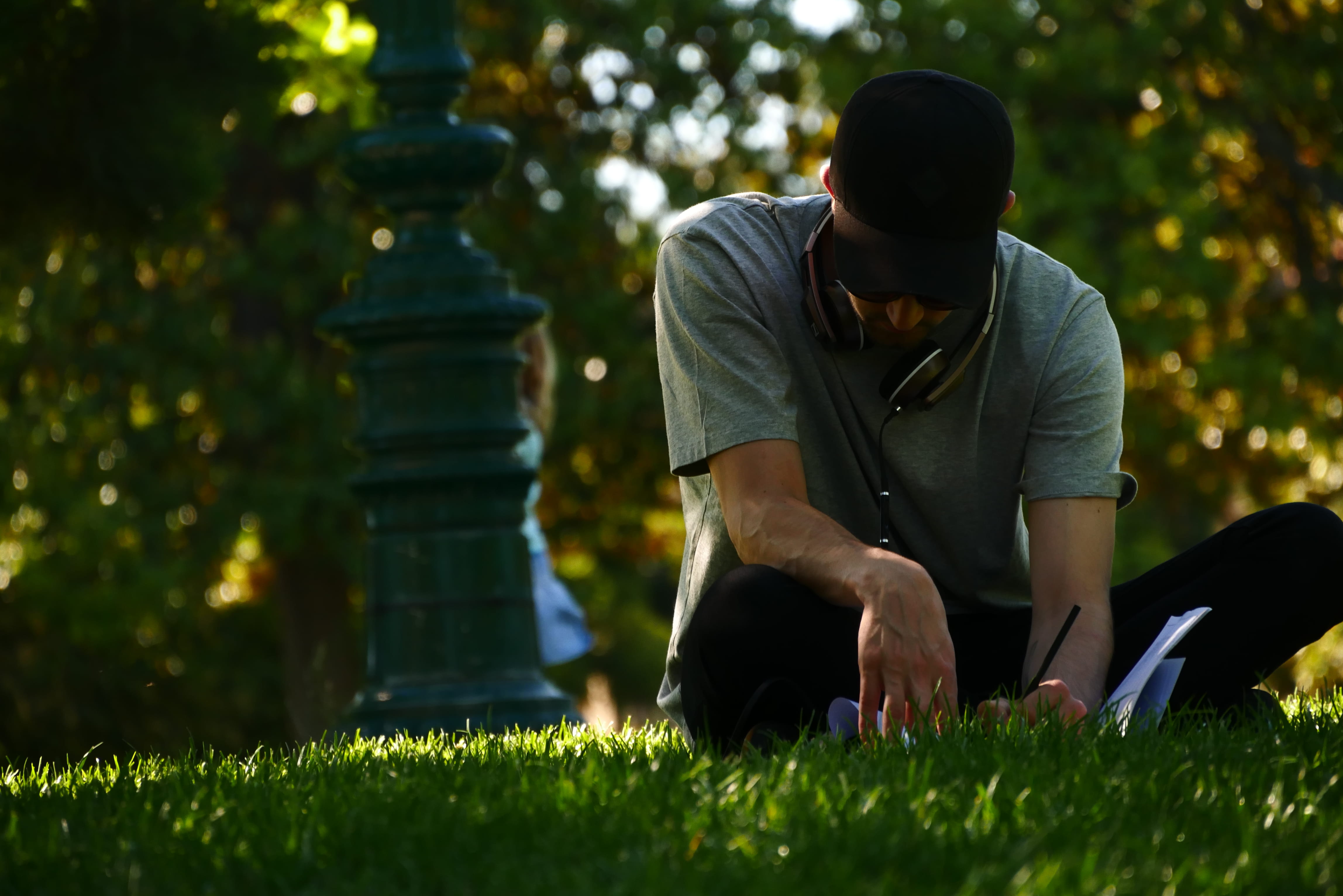 casual clothing, photography, sitting, focus, selective focus, relaxation, selective, young men, lifestyles, white paper, day, grass, plant, field, man, HD Wallpaper