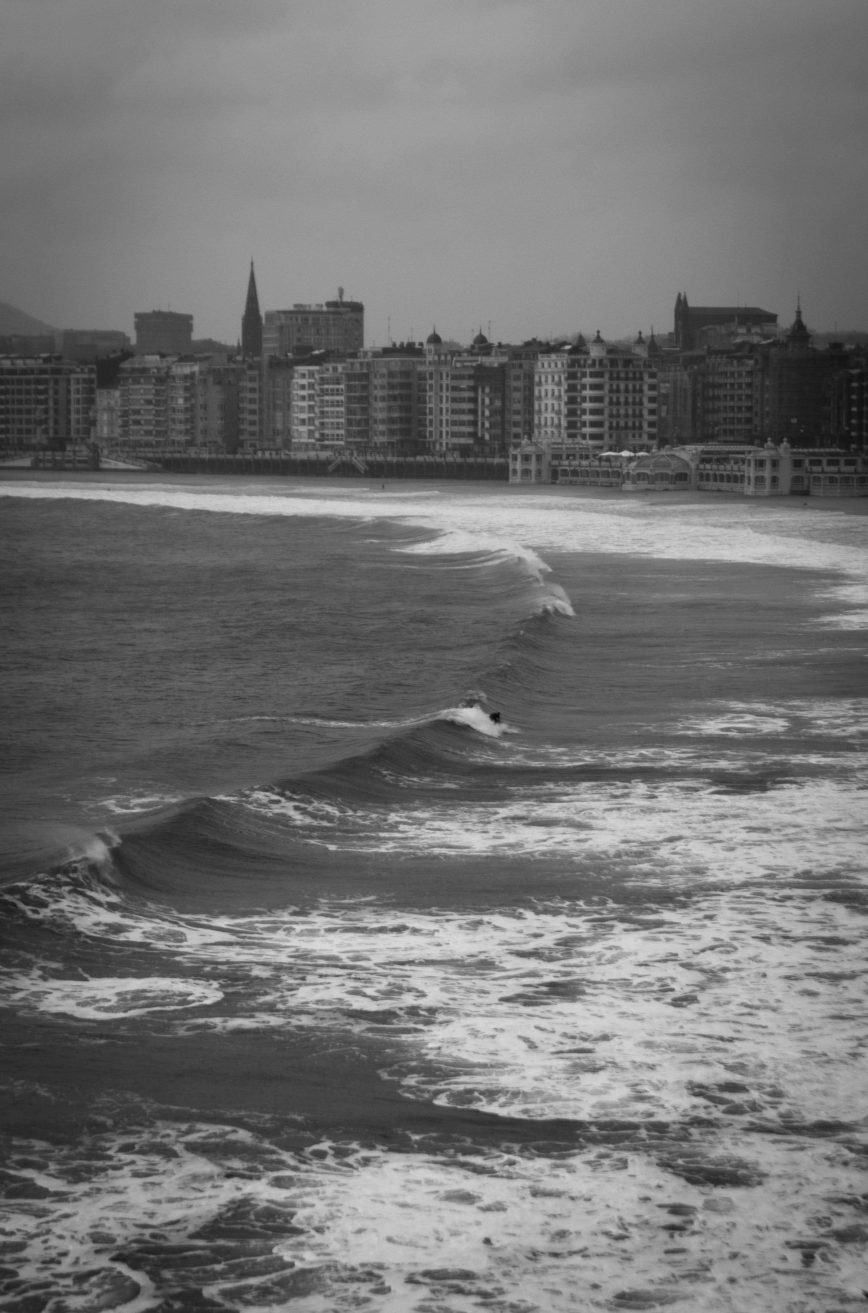 aquatic sport, sport, city, land, shell, winter, building, waterfront, Sea, wave, empty country, san sebastian, Beach, euskadi, office building exterior, Phone HD Wallpaper