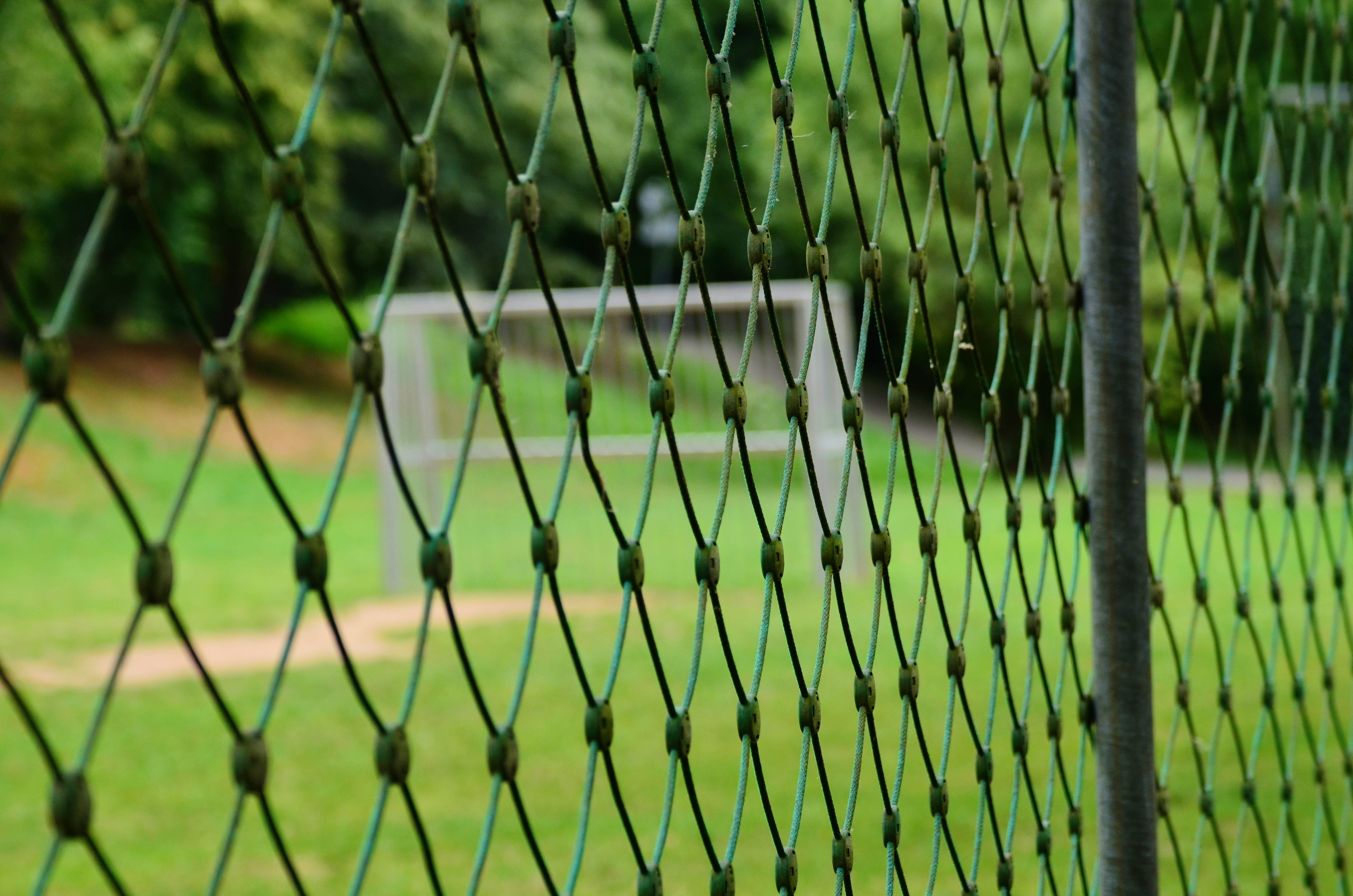 outdoors, focus on foreground, close-up, sport, pattern, barrier, protection, football field, day, crisscross, metal, boundary, green color, 4K, playing field, HD Wallpaper