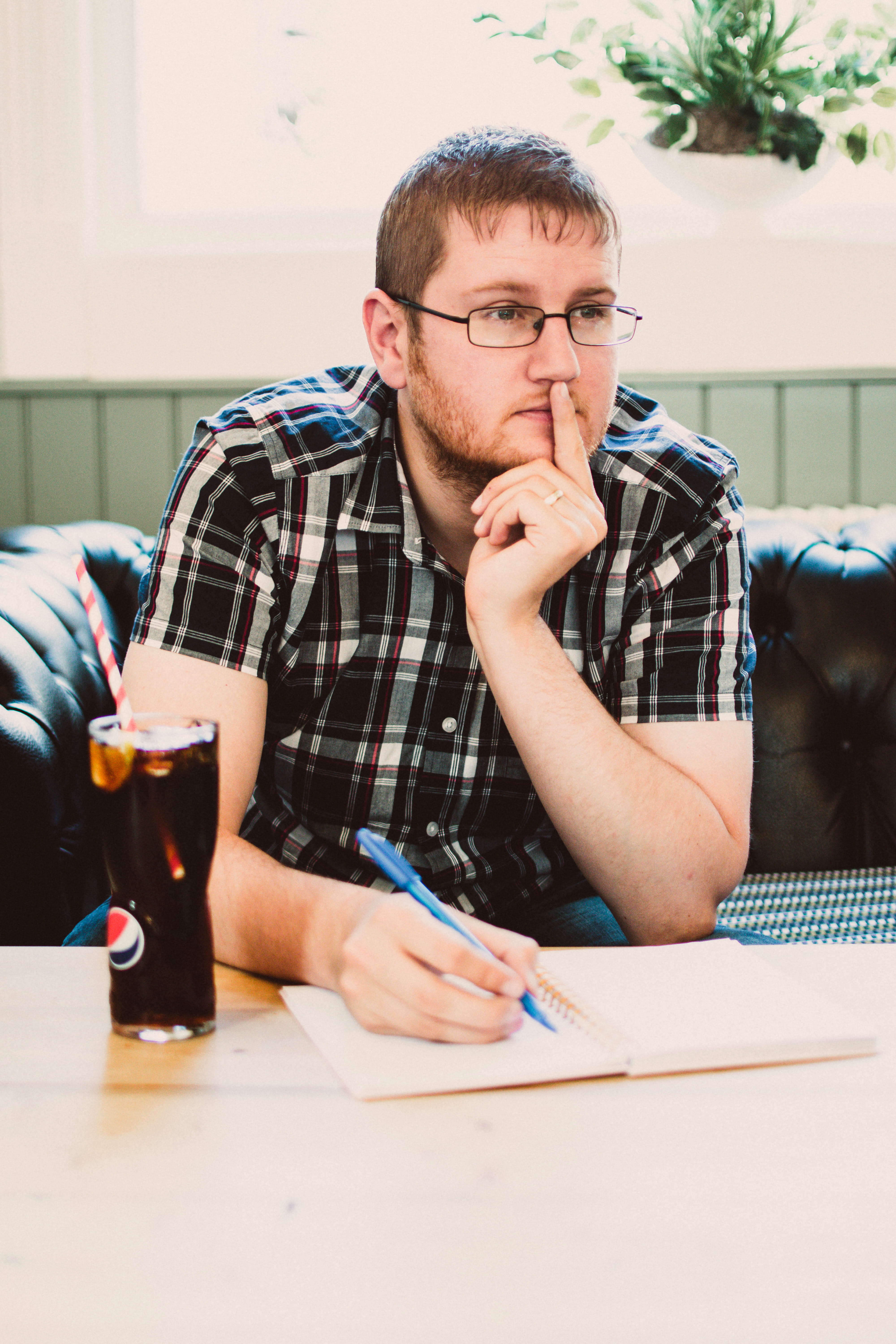 5K, wearing, table, glasses, wear, black, sit, learning, young men, person, shirt, furniture, pensive, real people, looking, plaid, man, beard, eye glasses, Phone HD Wallpaper