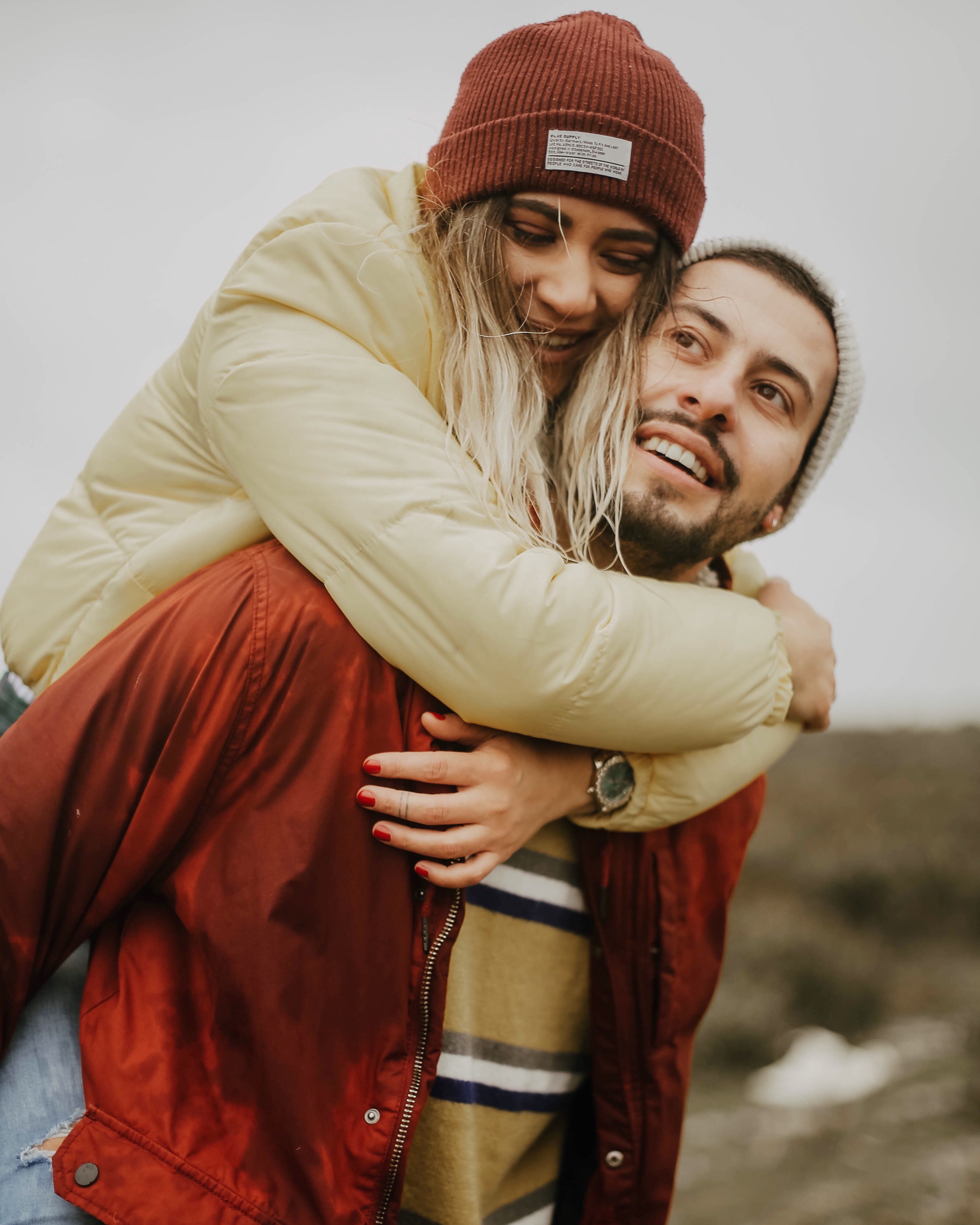 lifestyles, daytime, young women, red, young couple, smiling, couple, togetherness, warm clothing, winter, young adult, beannie, clothing, positive emotion, Phone HD Wallpaper