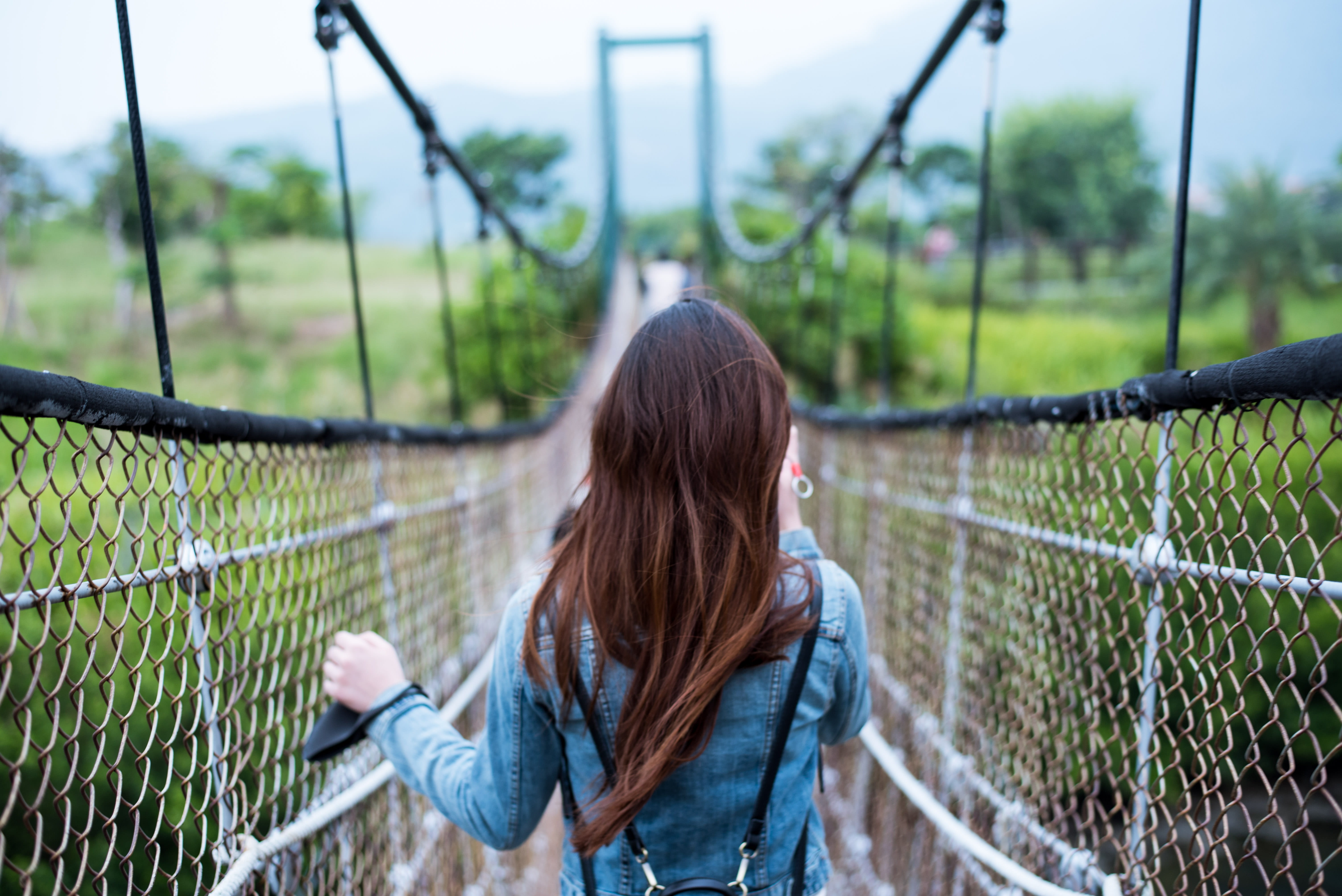 field, brown hair, sleeved, dress, path, 5K, outdoors, focus on foreground, grass, person, forward, recreation, fence, real people, bridge, long, female, HD Wallpaper