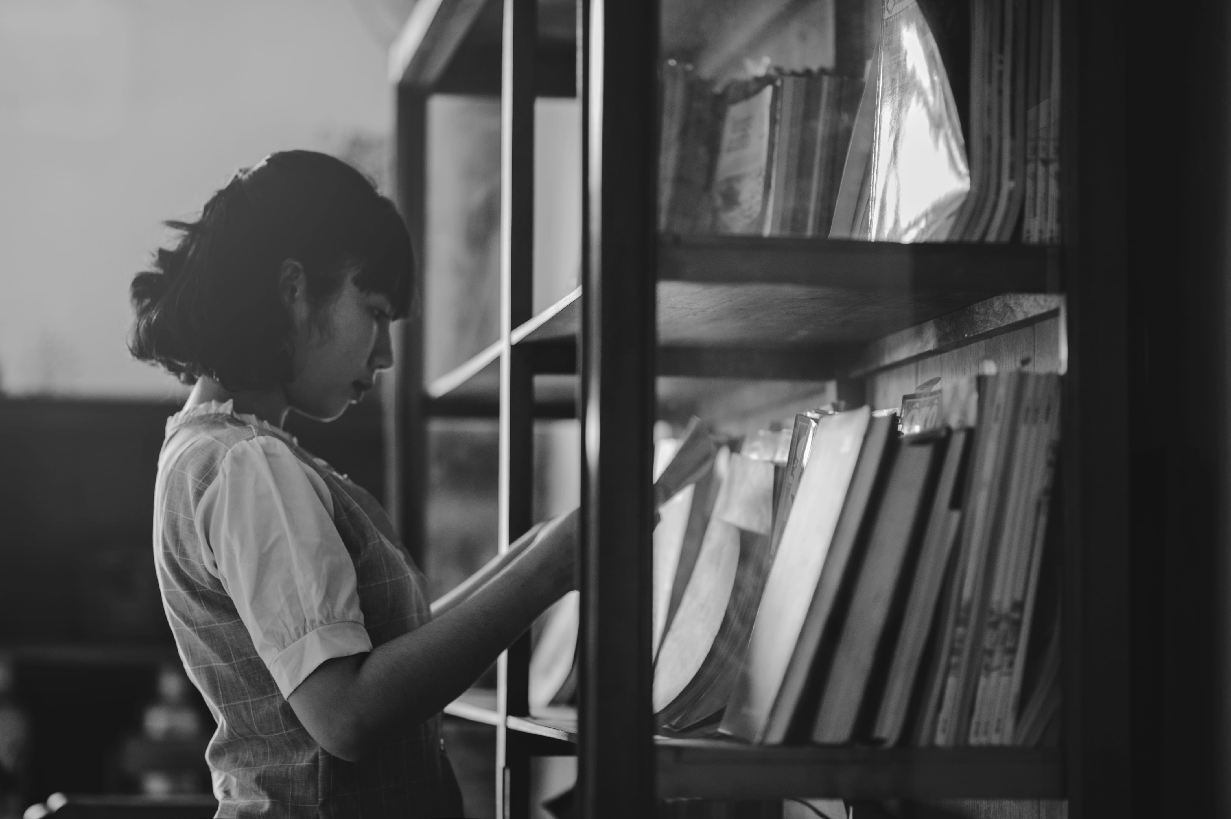 indoors, side view, day, grayscale, young adult, real people, glass - material, reading, woman, books, administration, standing, research, outfit, library, HD Wallpaper