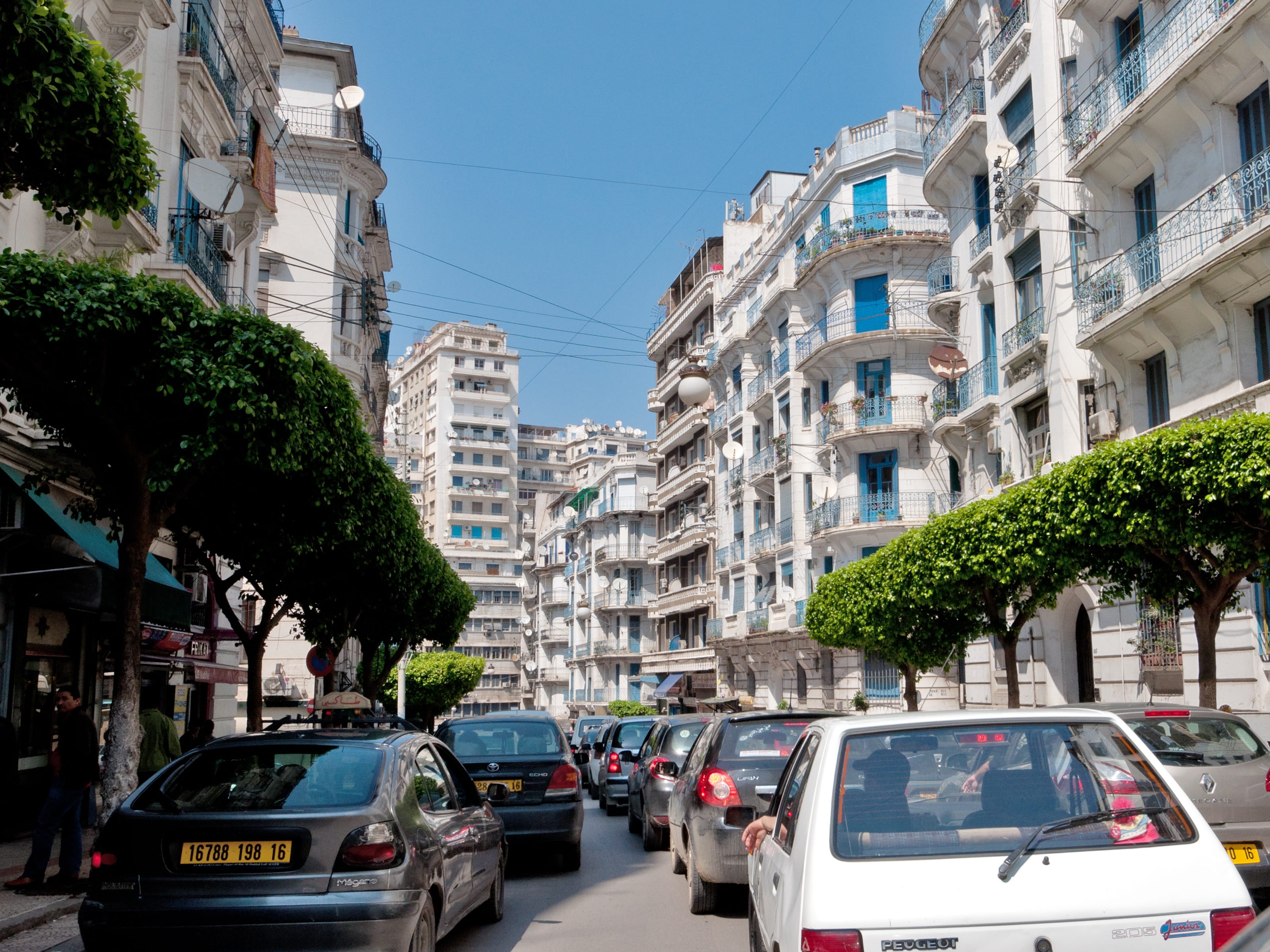 sky, road, land vehicle, outdoors, plant, Algeria, blue, built structure, city life, city, city street, 2K, architecture, apartment, building exterior, HD Wallpaper