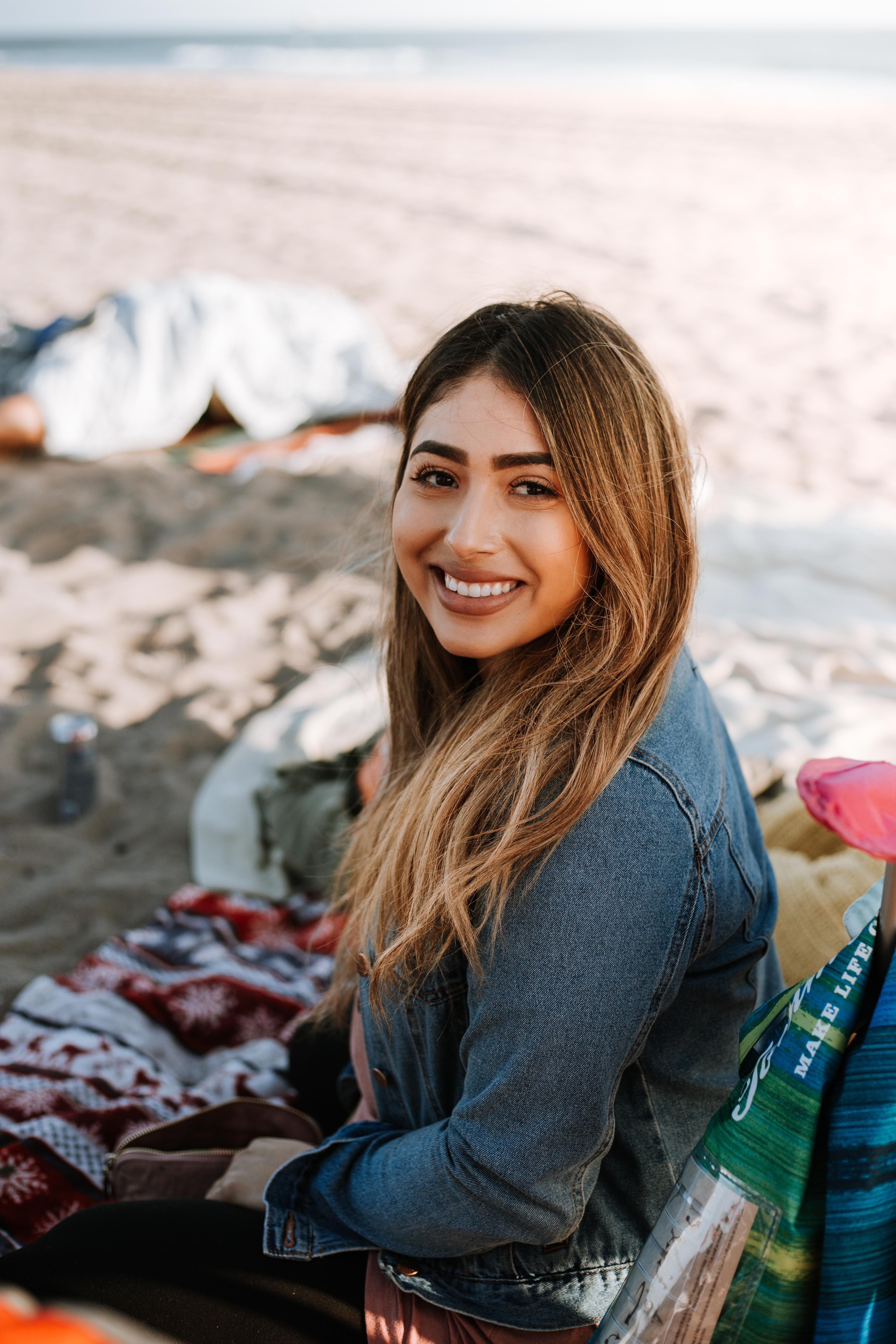 white, jean, real people, stand, seashore, smile, woman, portrait, fun, beautiful woman, sit, young women, casual clothing, one person, sitting, mexican, Phone HD Wallpaper