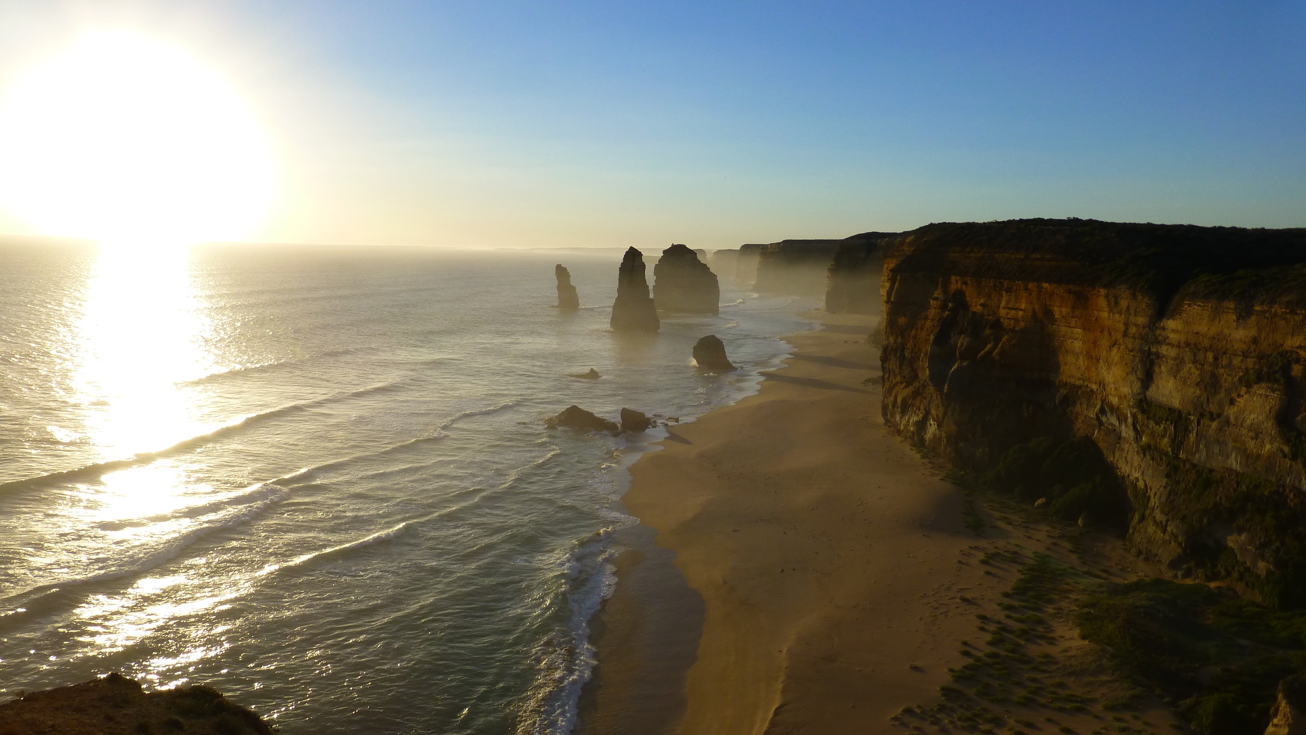 water, 4K, rock - object, solid, reflection, 12 apostles, sunlight, sky, sunset, body, australia, tranquil scene, cliff, sun, rock formation, tranquility, HD Wallpaper