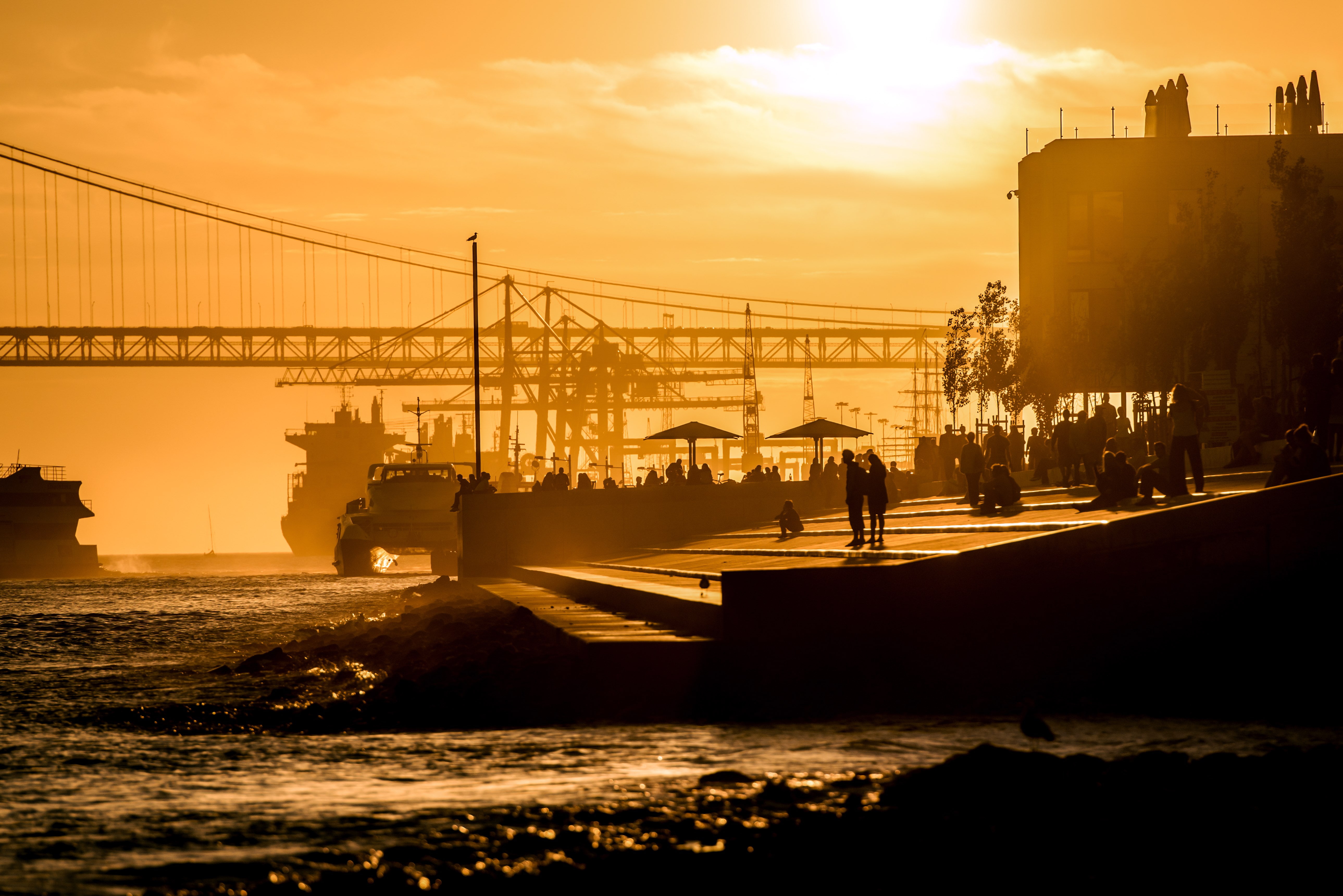 built structure, 5K, architecture, sky, bridge, cloud - sky, sunset, outdoors, engineering, sunlight, river, orange color, 25 de abril bridge, bridge - man made structure, HD Wallpaper