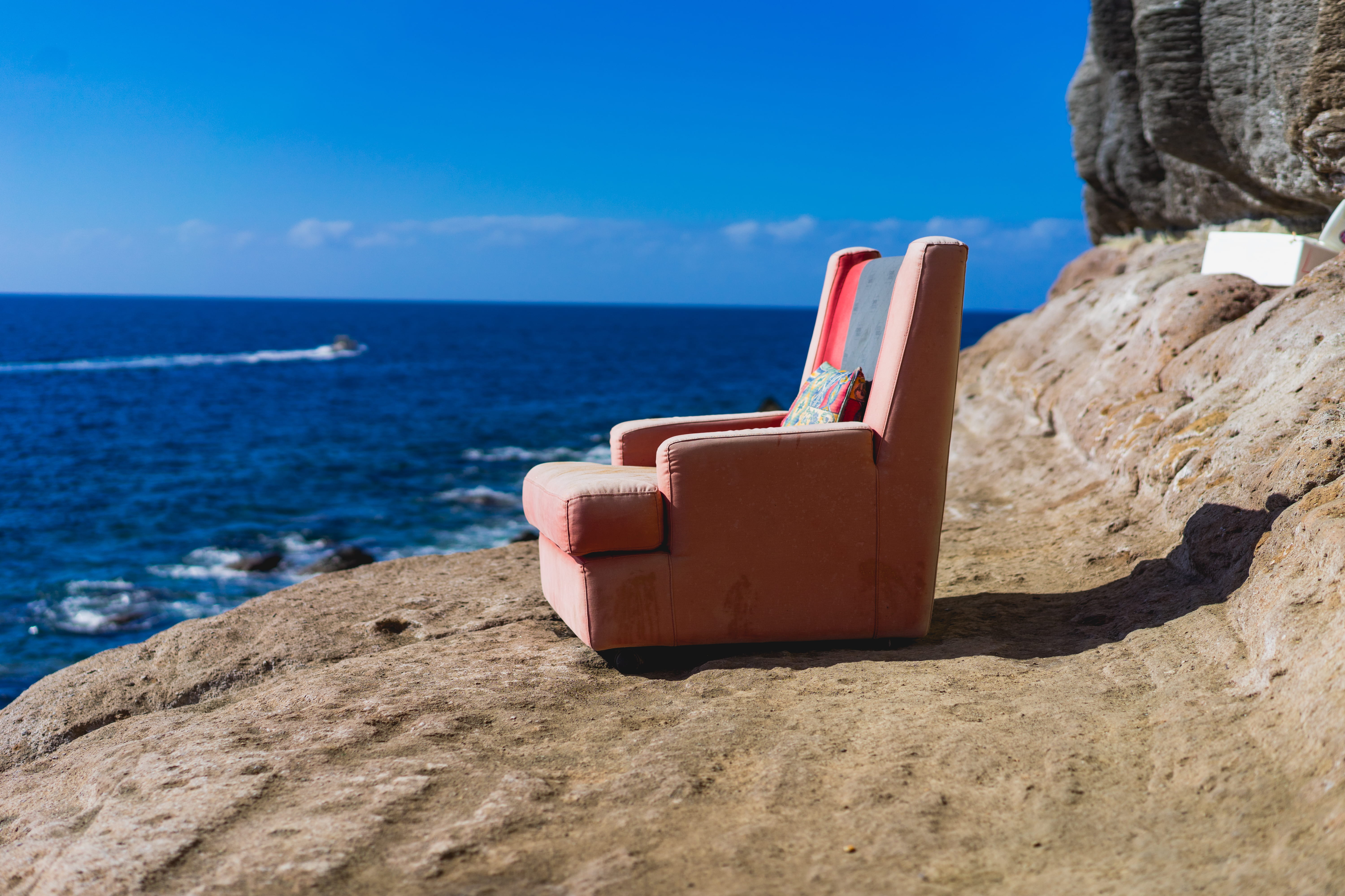 body, solid, beauty in nature, sofa, nature, no people, outdoors, blue, day, sky, 5K, fabric, tranquility, land, near, beach, sea, orange, horizon, rock, HD Wallpaper
