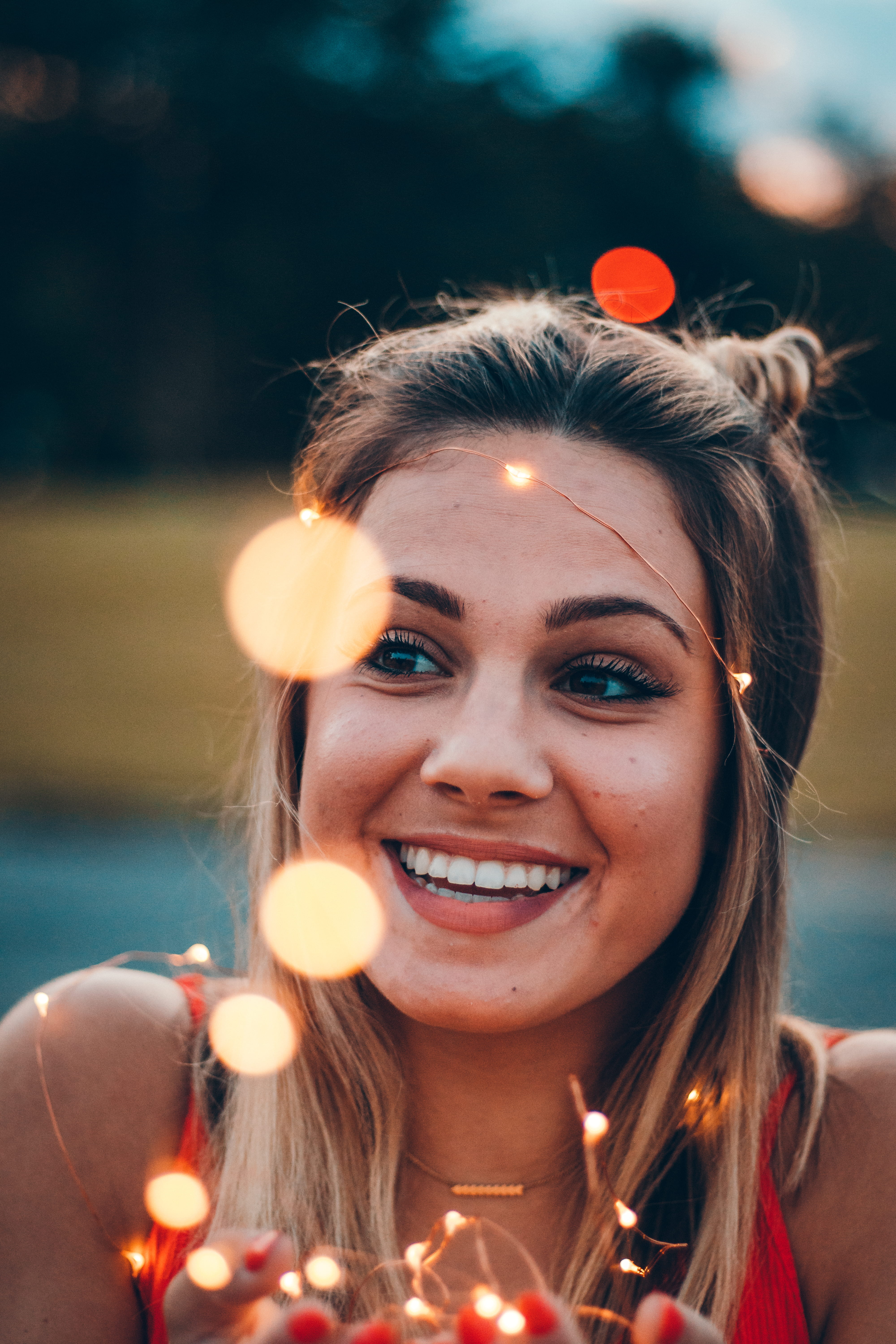 sports, focus on foreground, woman, blonde, 5K, lifestyles, real people, female, face, twinkle, twinkle lights, happiness, kid, string lights, looking at camera, Phone HD Wallpaper