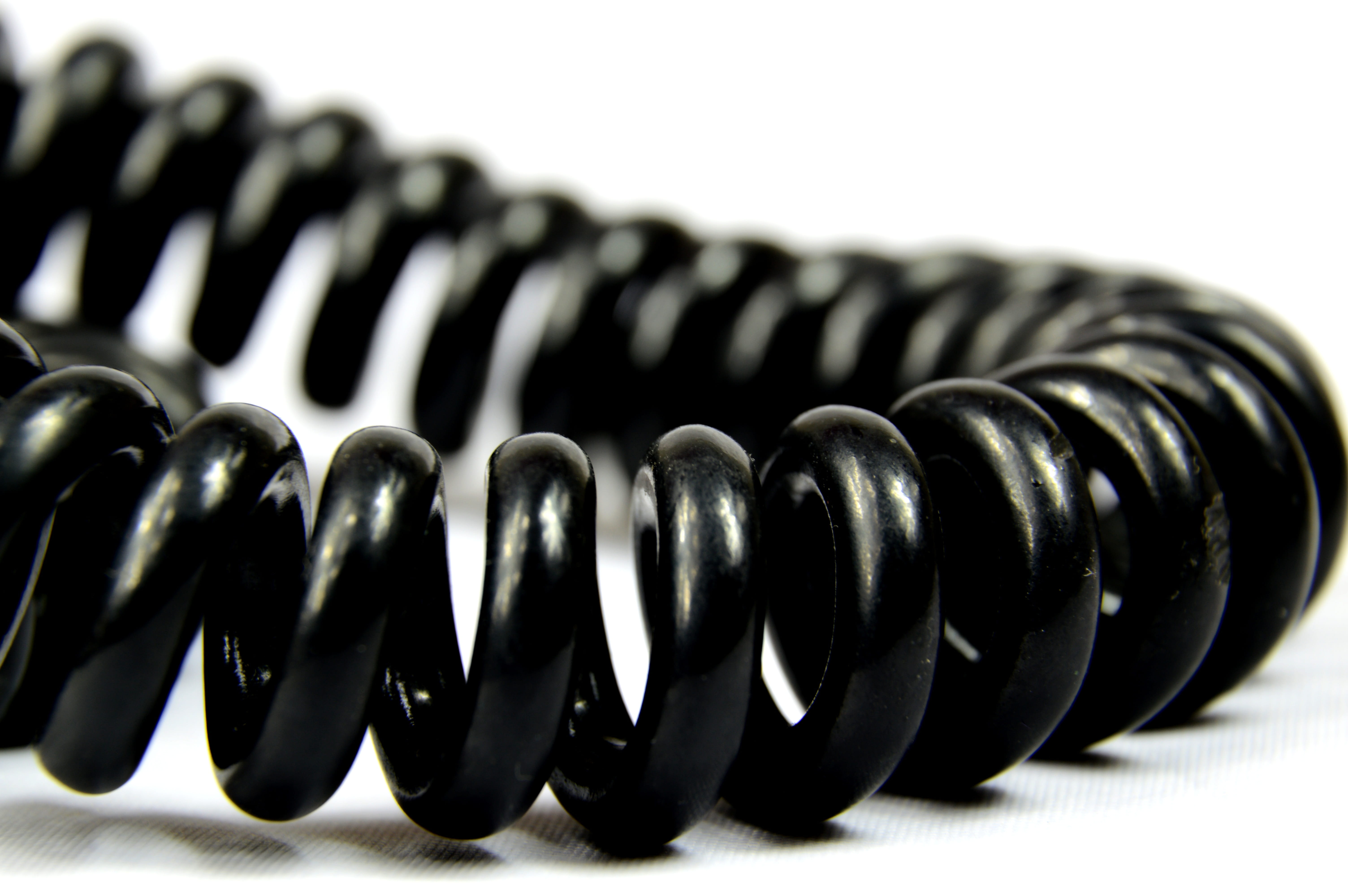 studio shot, 5K, focus on foreground, no people, spiral, single object, jewelry, black, the cord, table, indoors, alloy, in a row, close-up, bead, steel, HD Wallpaper