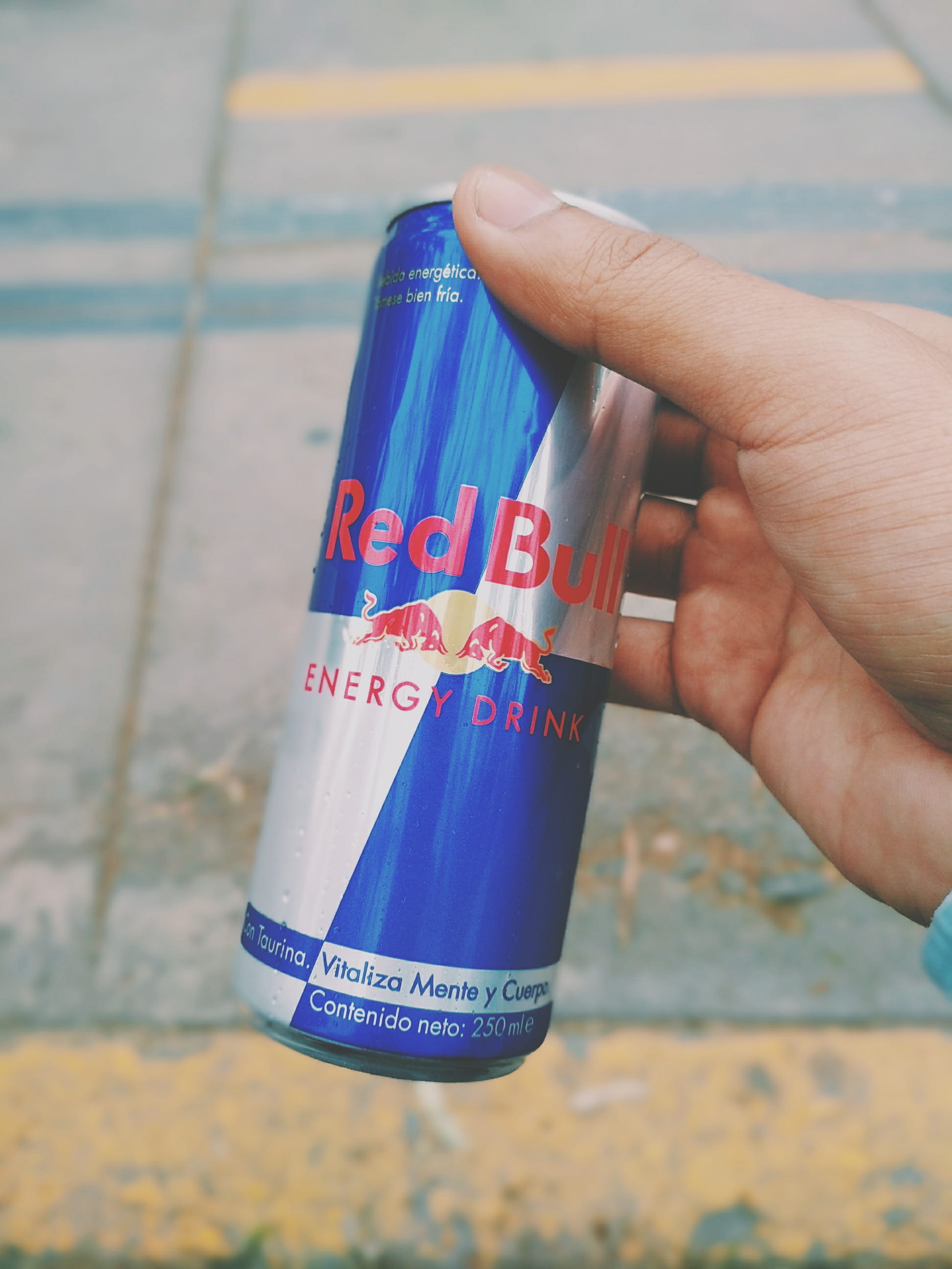 high angle view, focus on foreground, human finger, unrecognizable person, text, redbull, western script, message, human limb, holding, nail, finger, multi colored, Phone HD Wallpaper