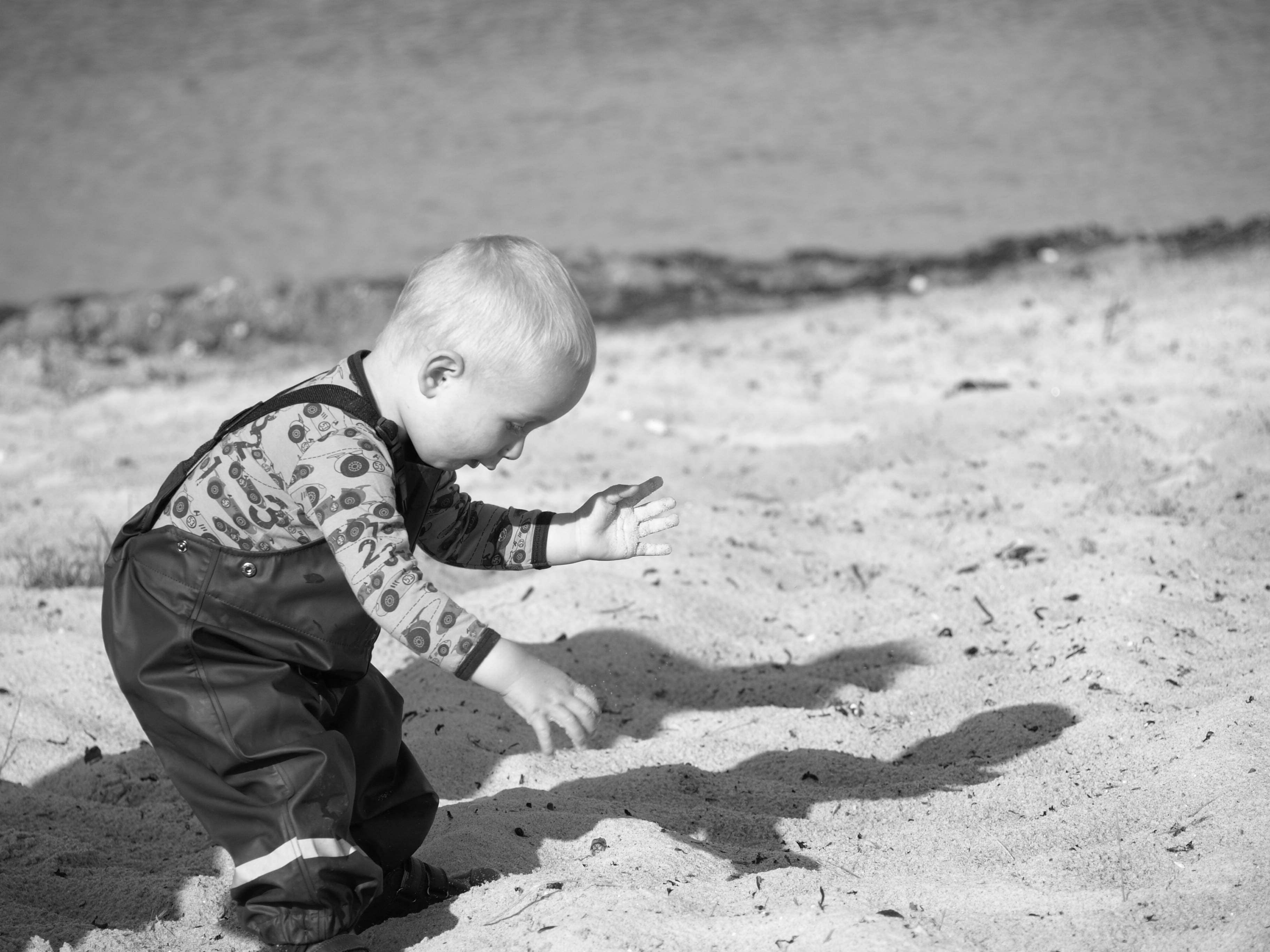one person, monochrome, 2K, lifestyles, real people, leisure activity, outdoors, land, toddler, young, boys, beach, recreation, sunlight, seashore, full length, HD Wallpaper