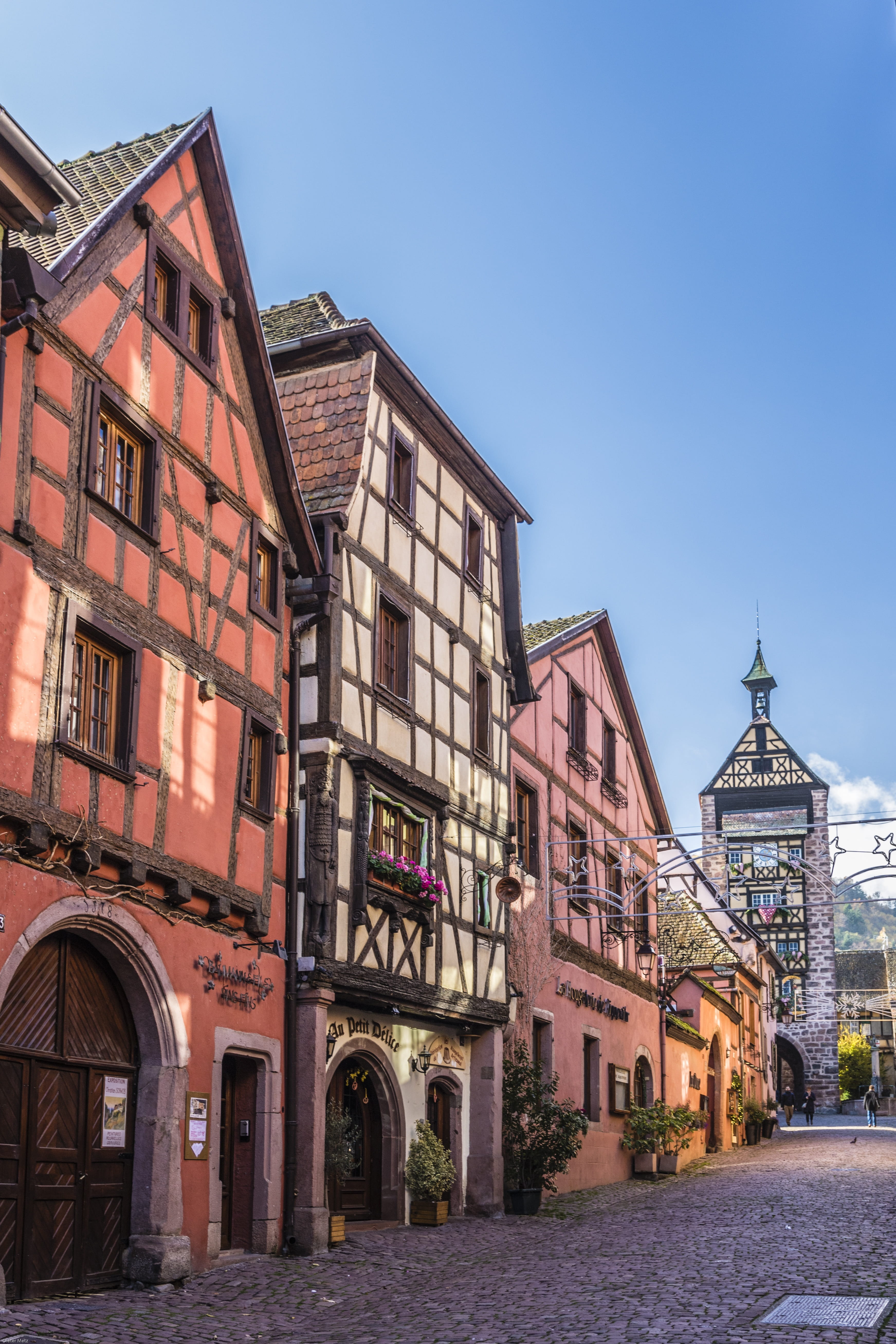 architecture, clear sky, alsace, france, built structure, day, building exterior, 5K, picturesque, street, belief, arch, residential district, sky, blue, Phone HD Wallpaper