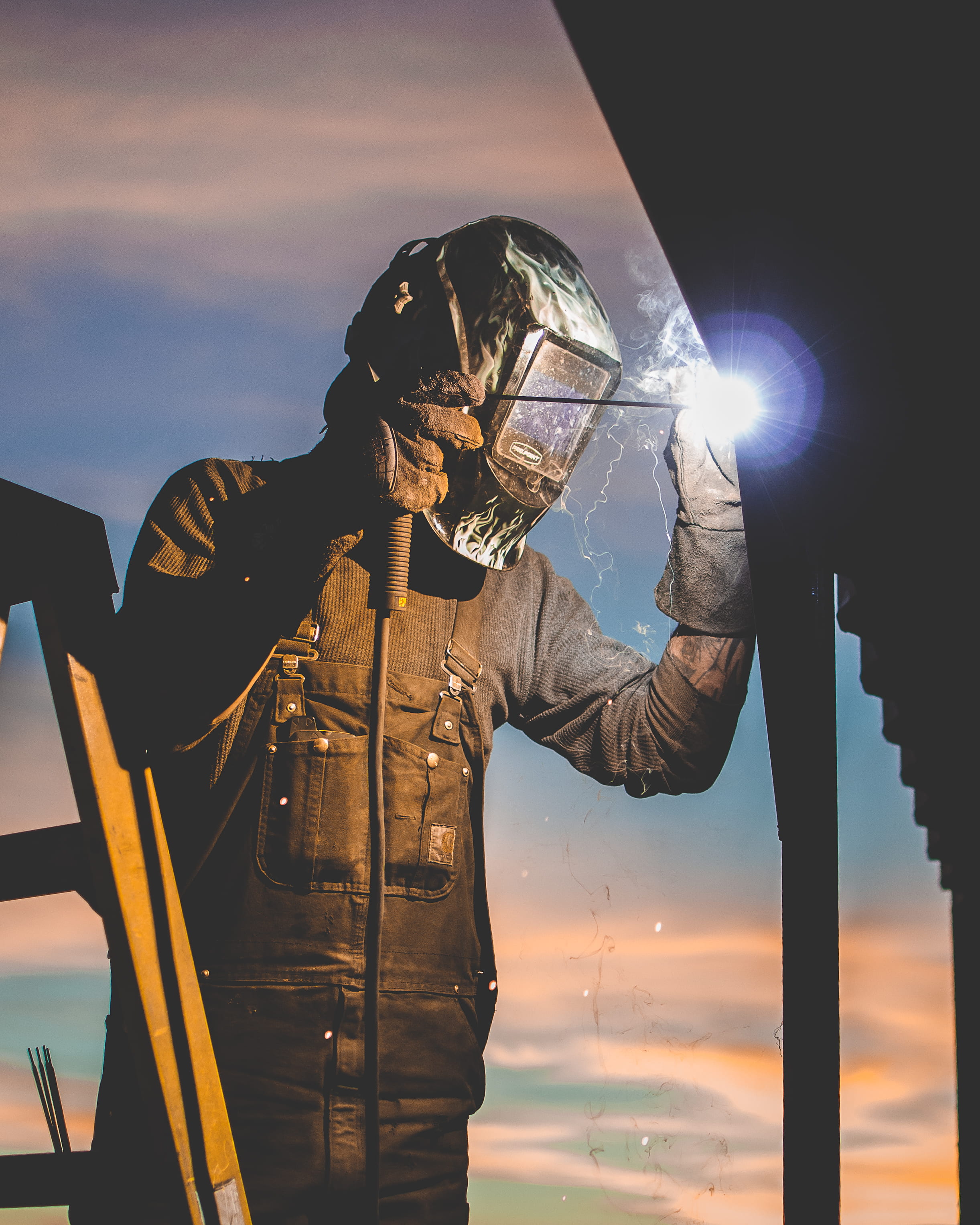 headwear, security, sunrise, post, male, silhouette, protective workwear, spark, dark, one person, workman, welds, illuminated, obscured face, technology, Phone HD Wallpaper