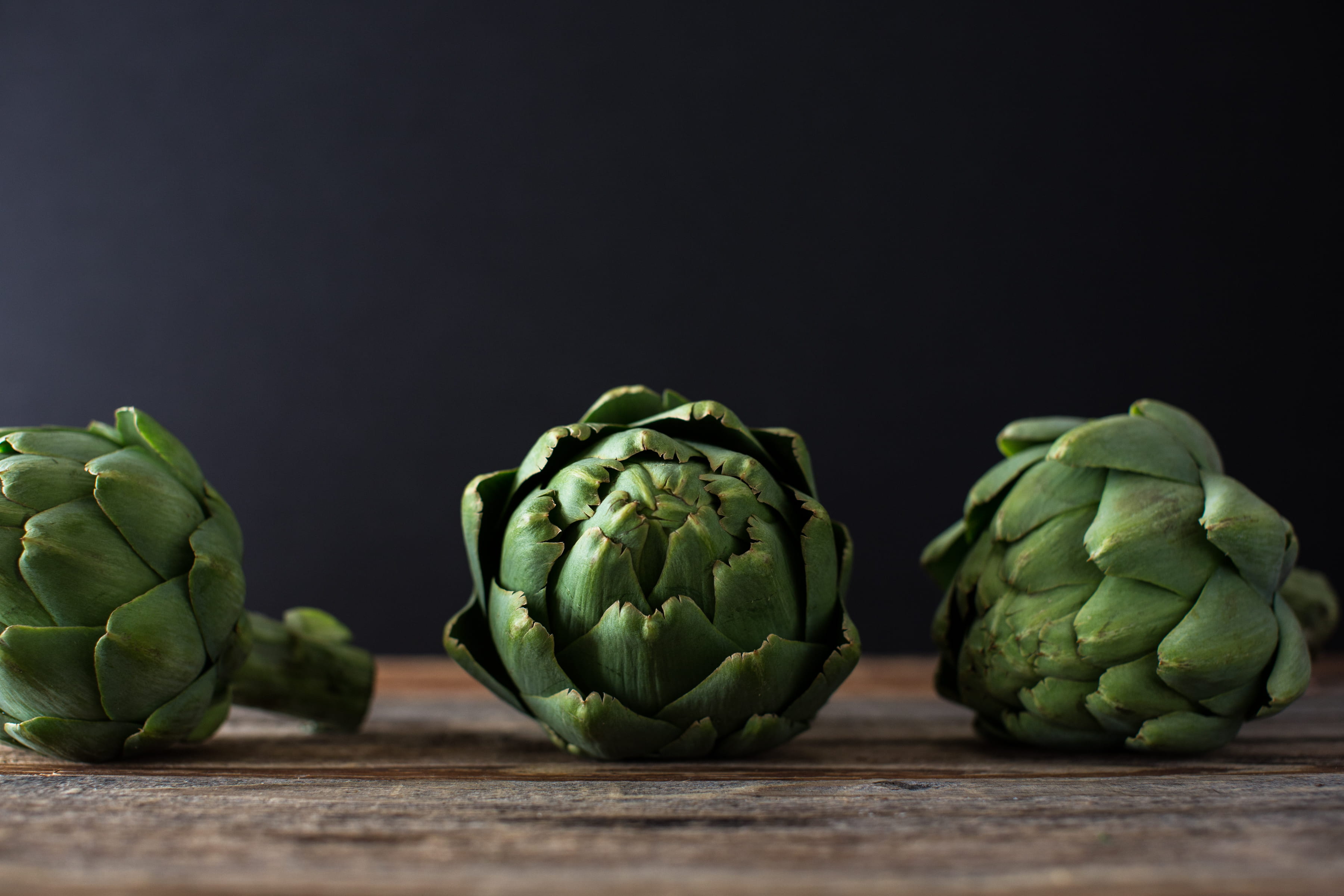 black background, artichoke, still life, 2K, artichokes, healthy lifestyle, vegetable, leaf, shallow, healthy eating, photo, wooden, no people, raw food, HD Wallpaper