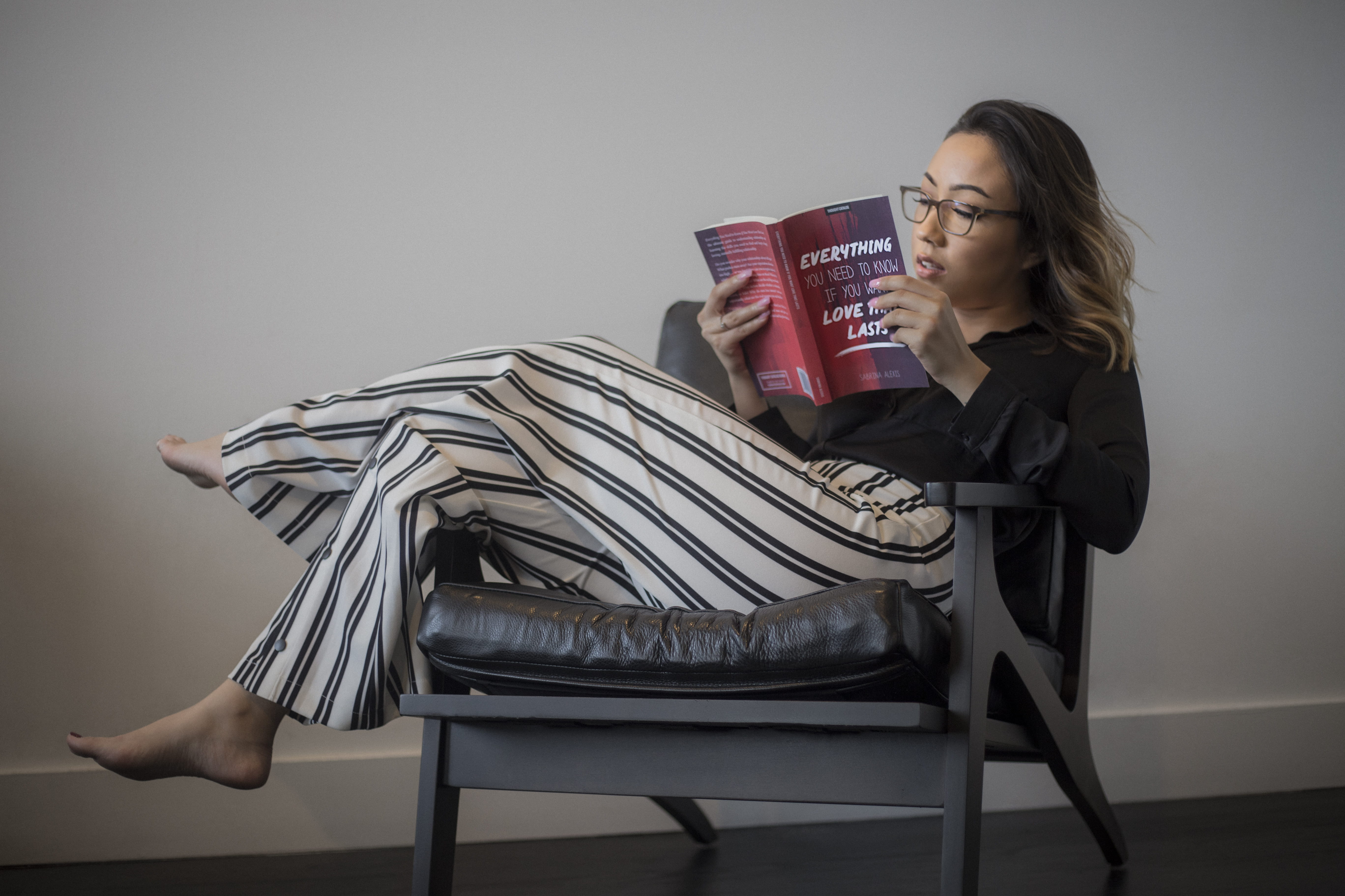 literature, striped, furniture, wooden, wear, armchair, young women, white, woman, girl, seat, chair, knowledge, hairstyle, pants, book, 5K, framed, comfortable, HD Wallpaper