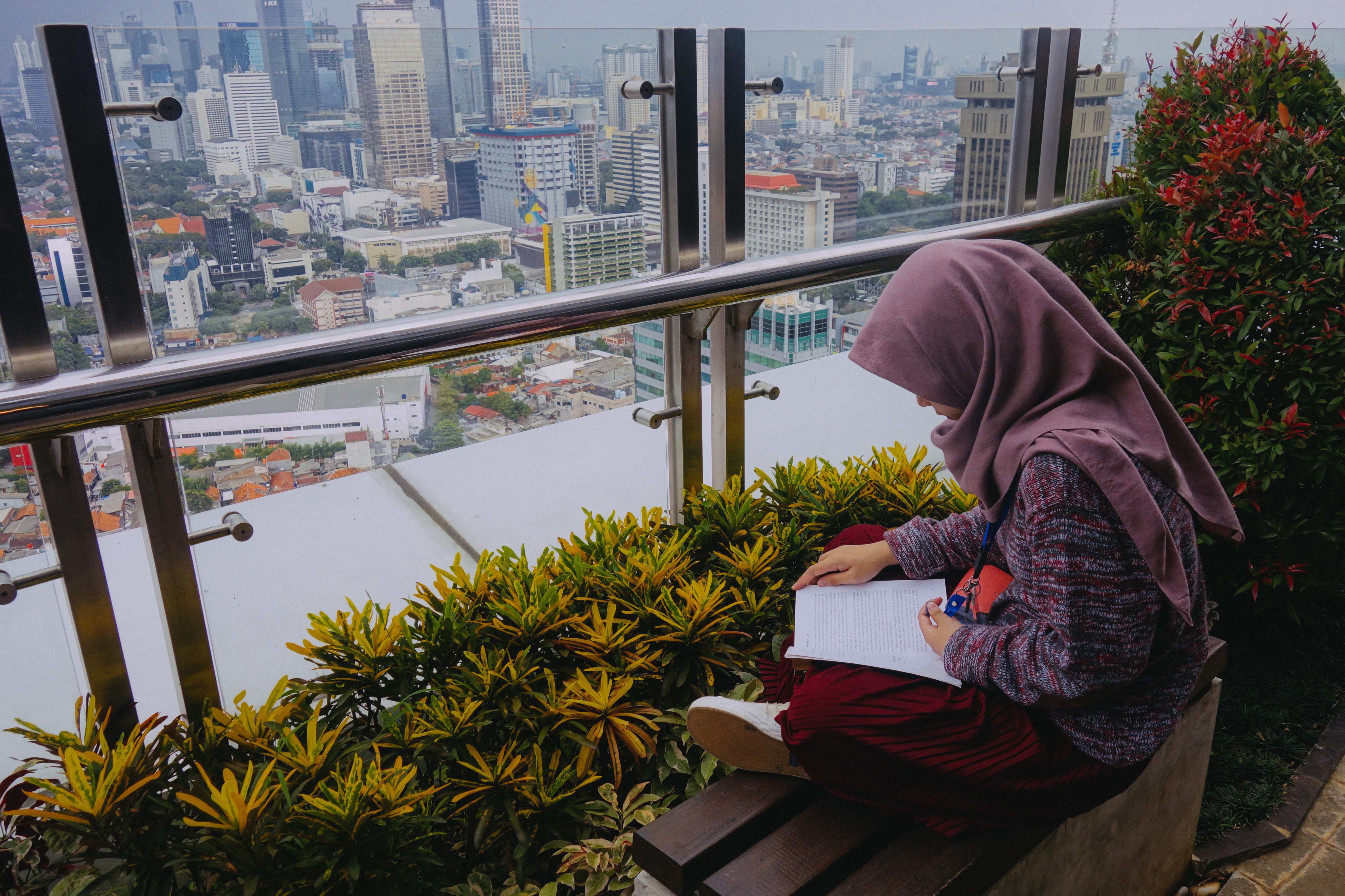 three quarter length, outdoors, cityscape, bench, clothing, woman, sweatshirt, person, city, balcony, jakarta, architecture, building, built structure, HD Wallpaper