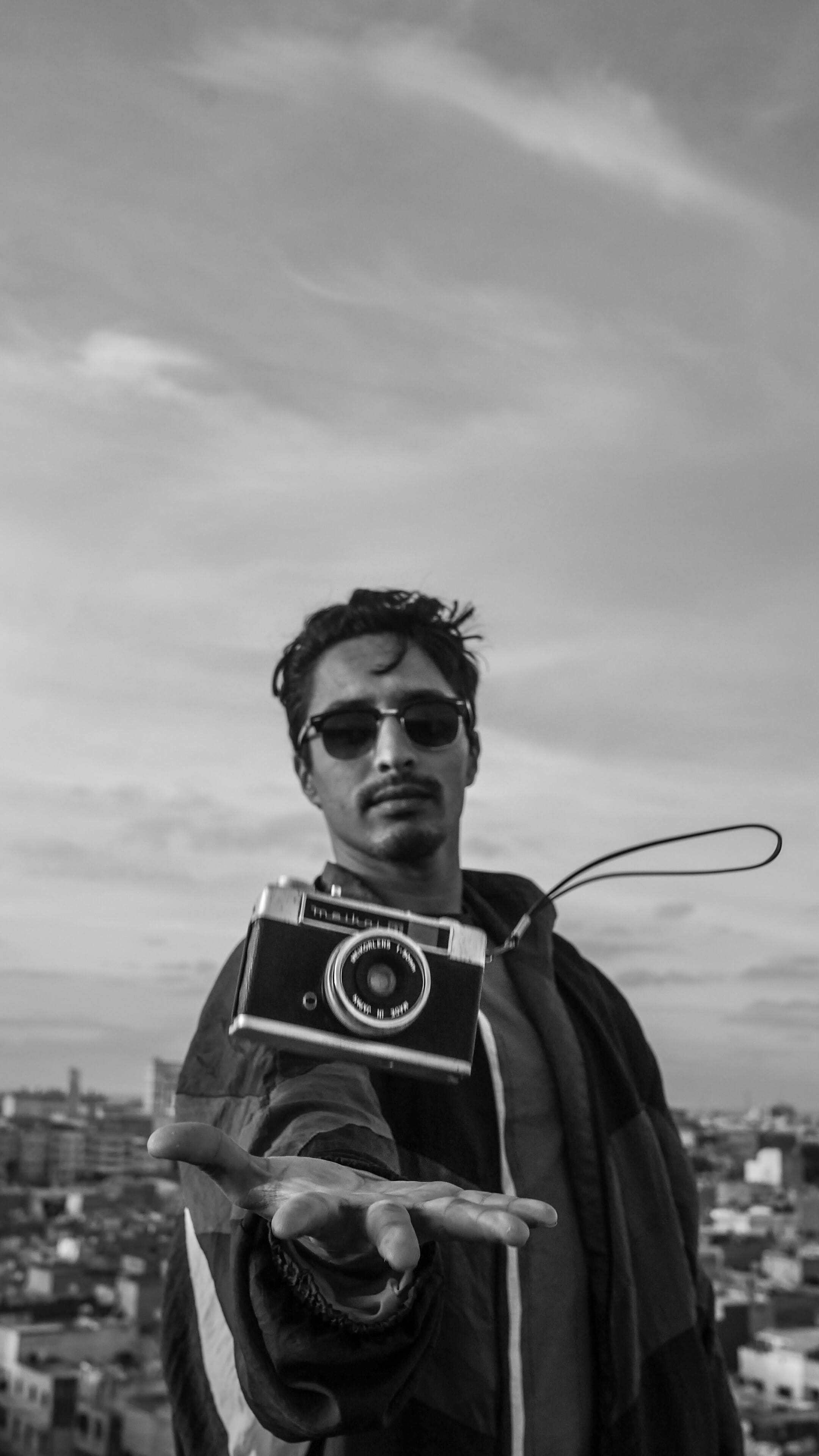 person, photographer, human, nature, photo, electronics, outdoors, holding, black and white, man, sunglasses, young men, bandw, waist up, day, 4K, young adult, Phone HD Wallpaper