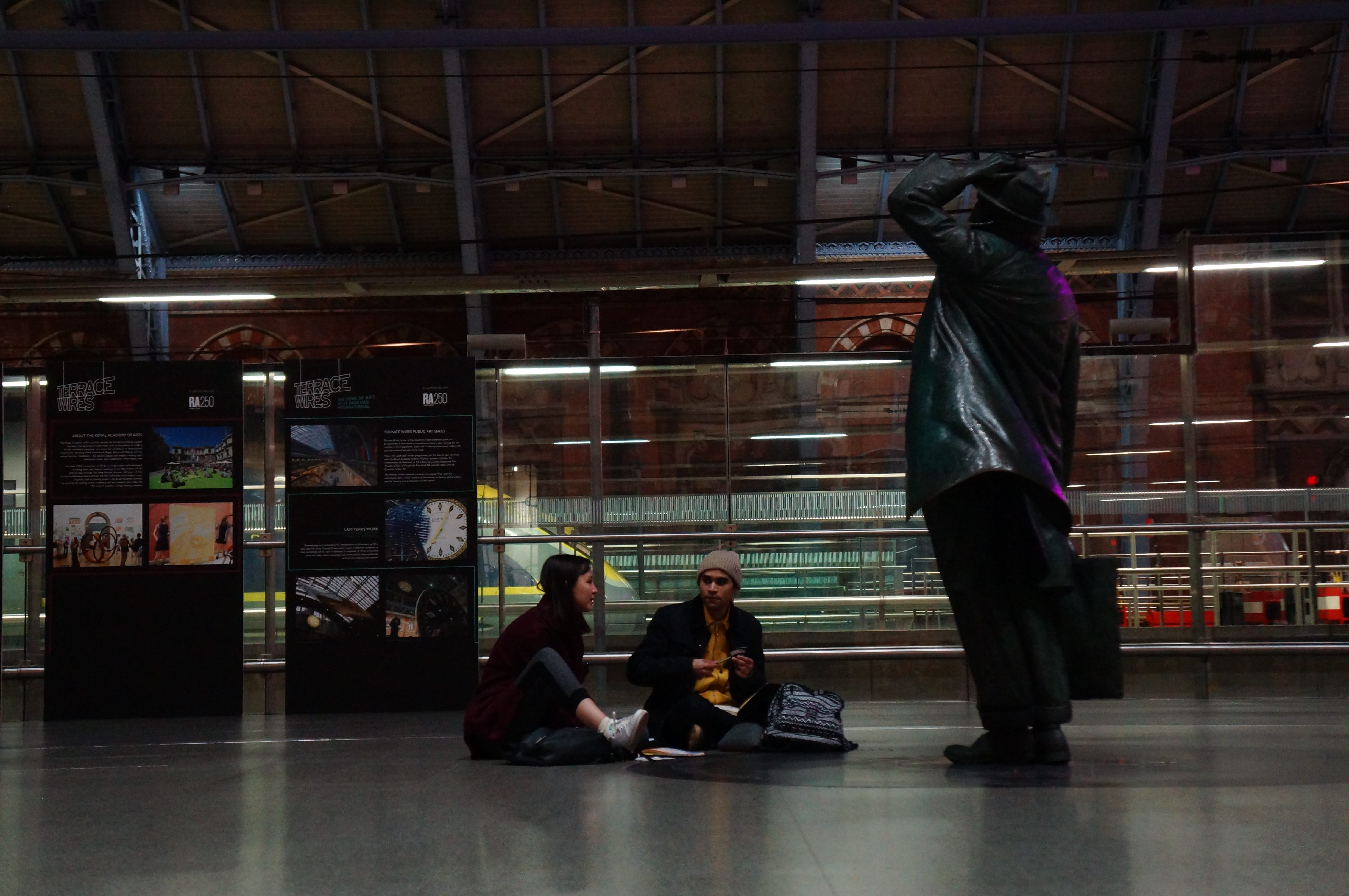apparel, sitting, floor, men, 4K, lifestyles, teenagers, clothing, flooring, group of people, pants, londres, lighting, united kingdom, st pancras, statue, HD Wallpaper