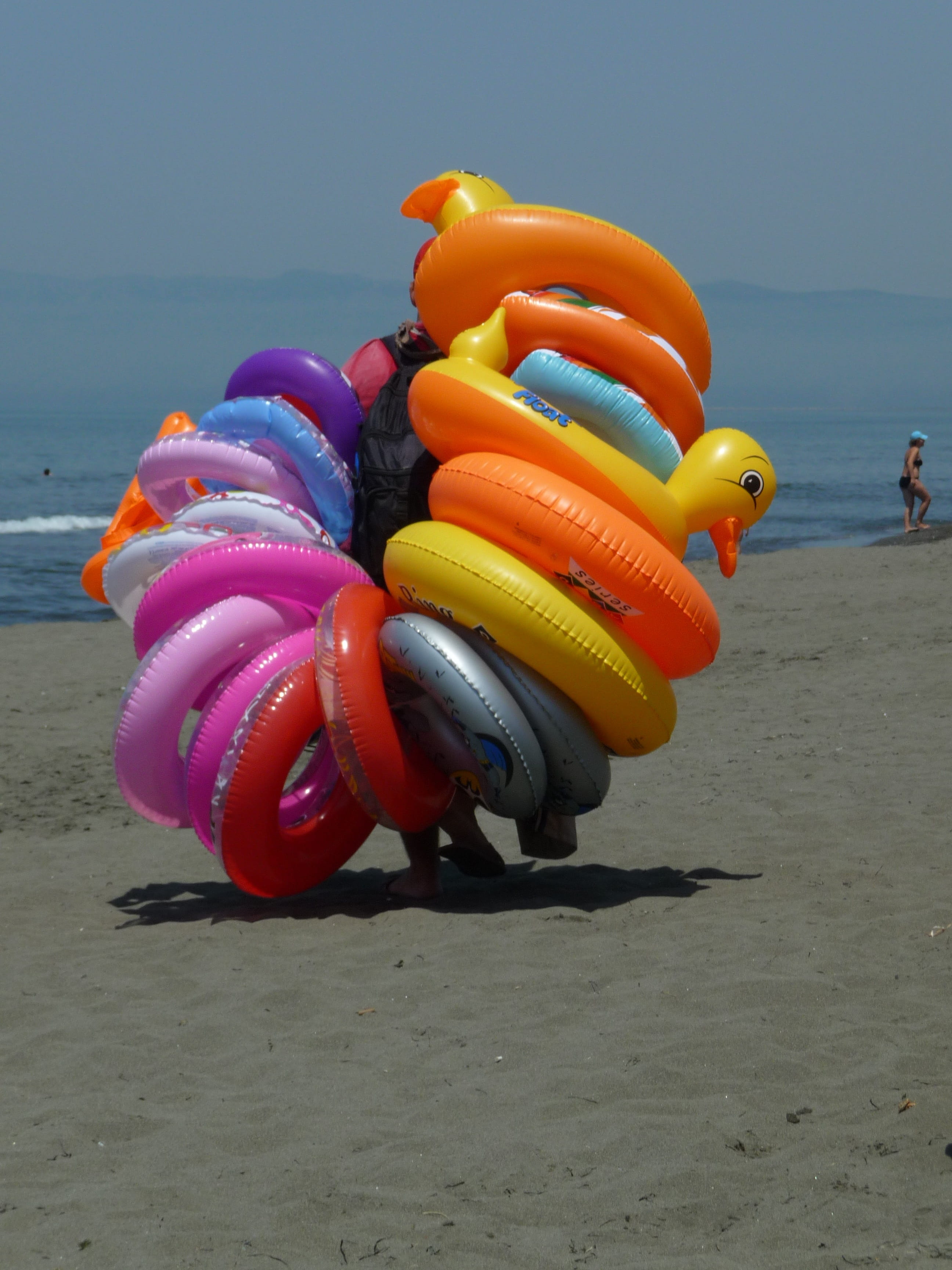 childhood, floating on water, water, day, sky, Beach, land, multi colored, vacations, nature, inflatable, sunlight, close-up, orange color, sea, Donut, Phone HD Wallpaper