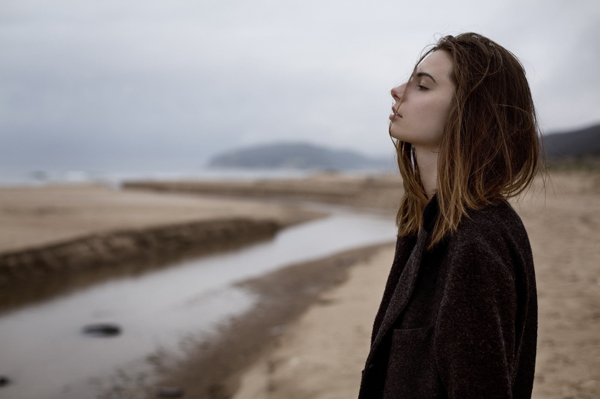 coats, women outdoors, model, 1080P, blonde, hair, contemplation, women on beach, one person, outdoors, nature, black coat, women, depth of field, young adult, HD Wallpaper