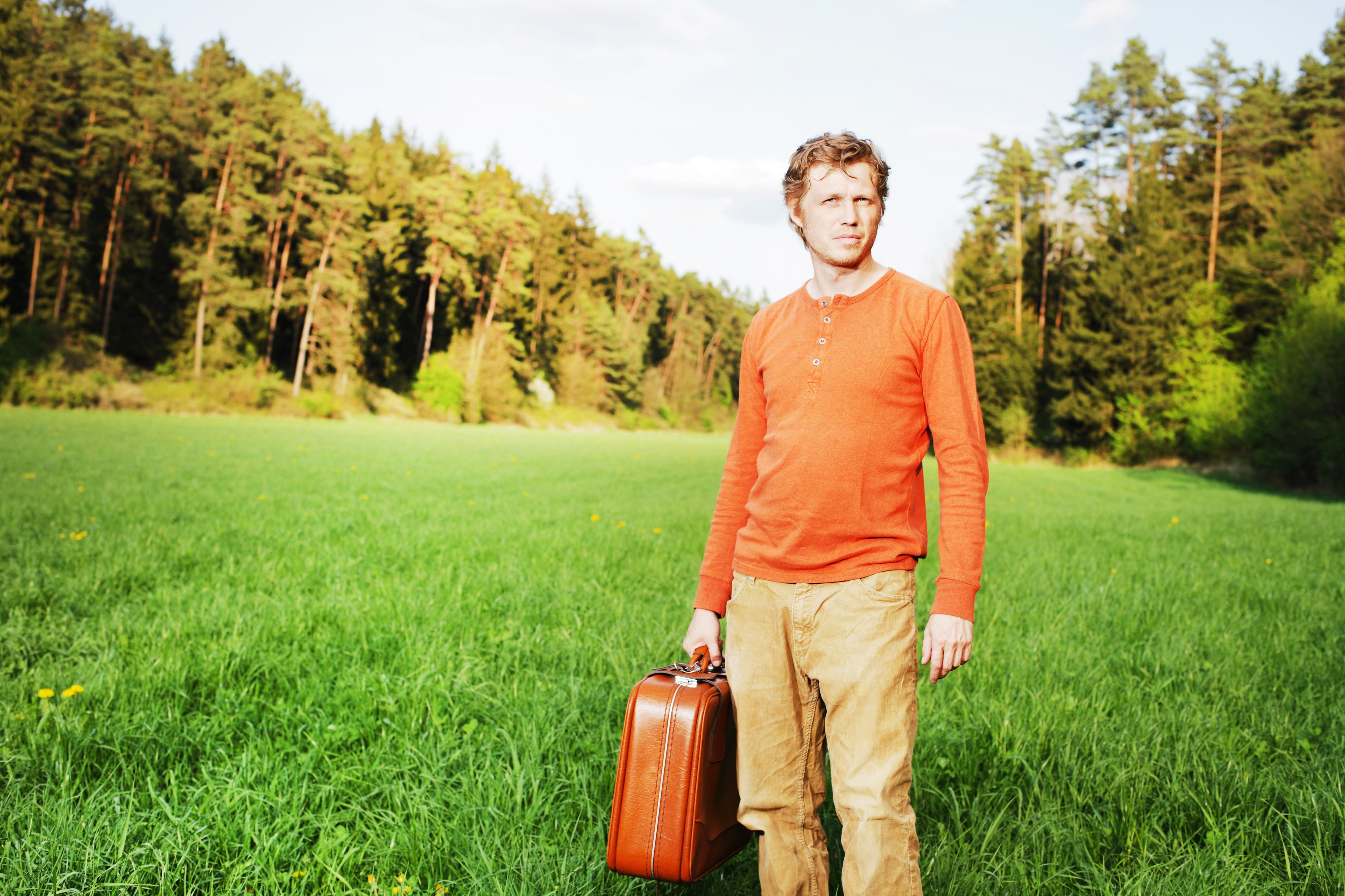 man, men, field, person, denim jeans, outdoors, green color, brown, time, grass, denim, real people, luggage, travel, green grass, one person, casual clothing, HD Wallpaper