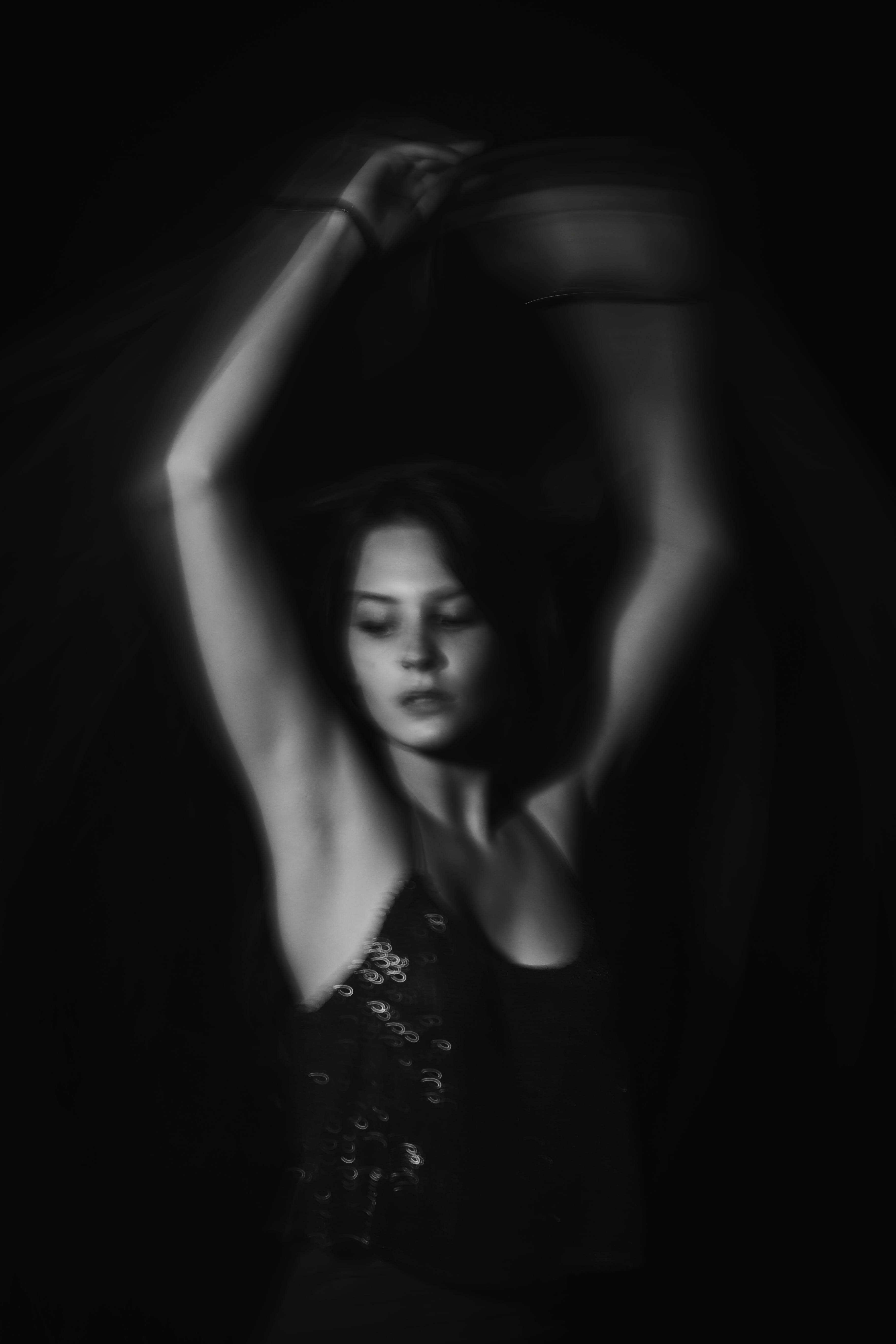 indoors, contemplation, arms raised, dark, front view, motion, studio shot, blackandwhite, girl, beauty, black and white, young adult, 50mm, blur, light and shadow, Phone HD Wallpaper