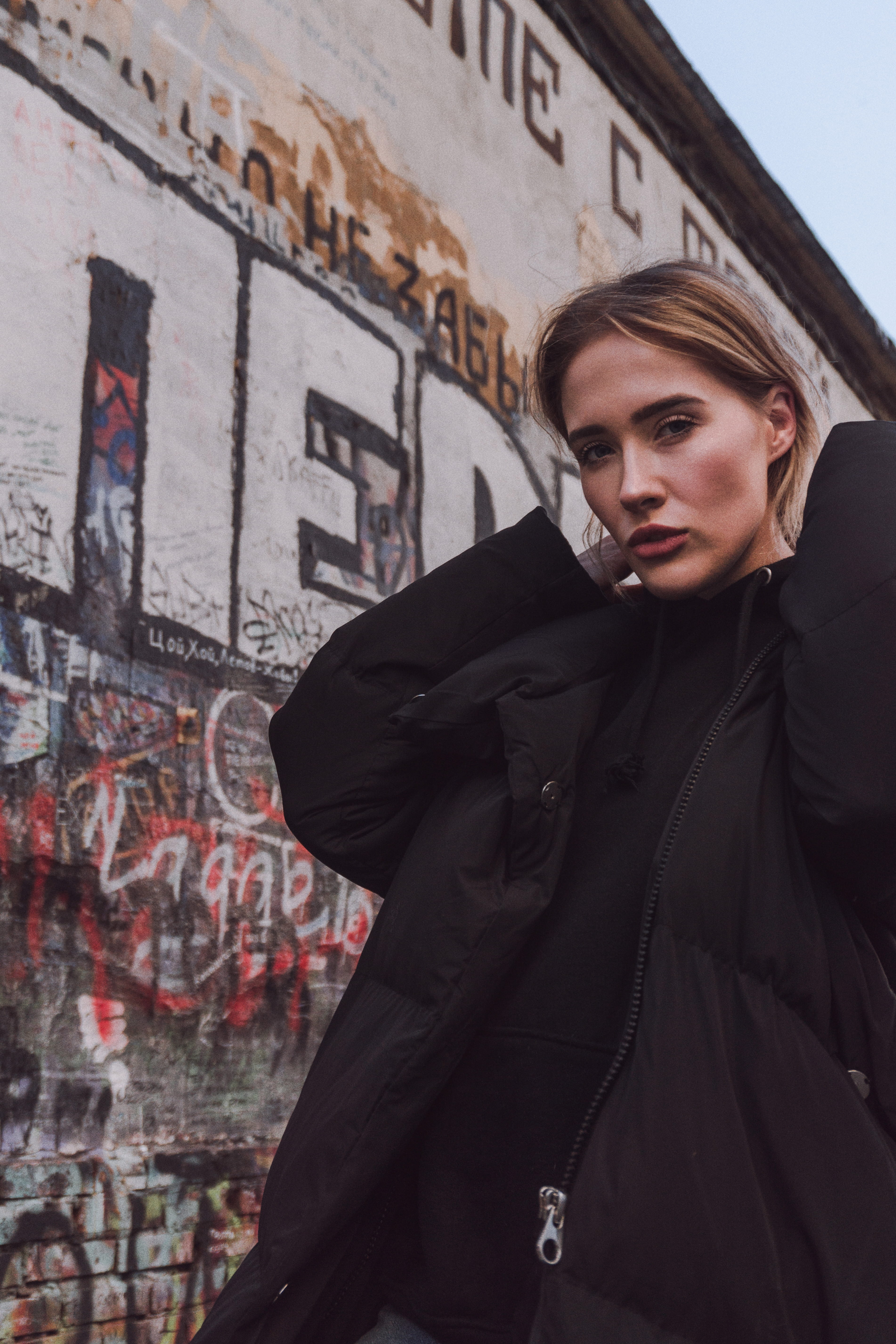 looking at camera, leather jacket, young women, coat, contemplation, leisure activity, human, mural, portrait, 5K, woman, architecture, real people, wall, Phone HD Wallpaper
