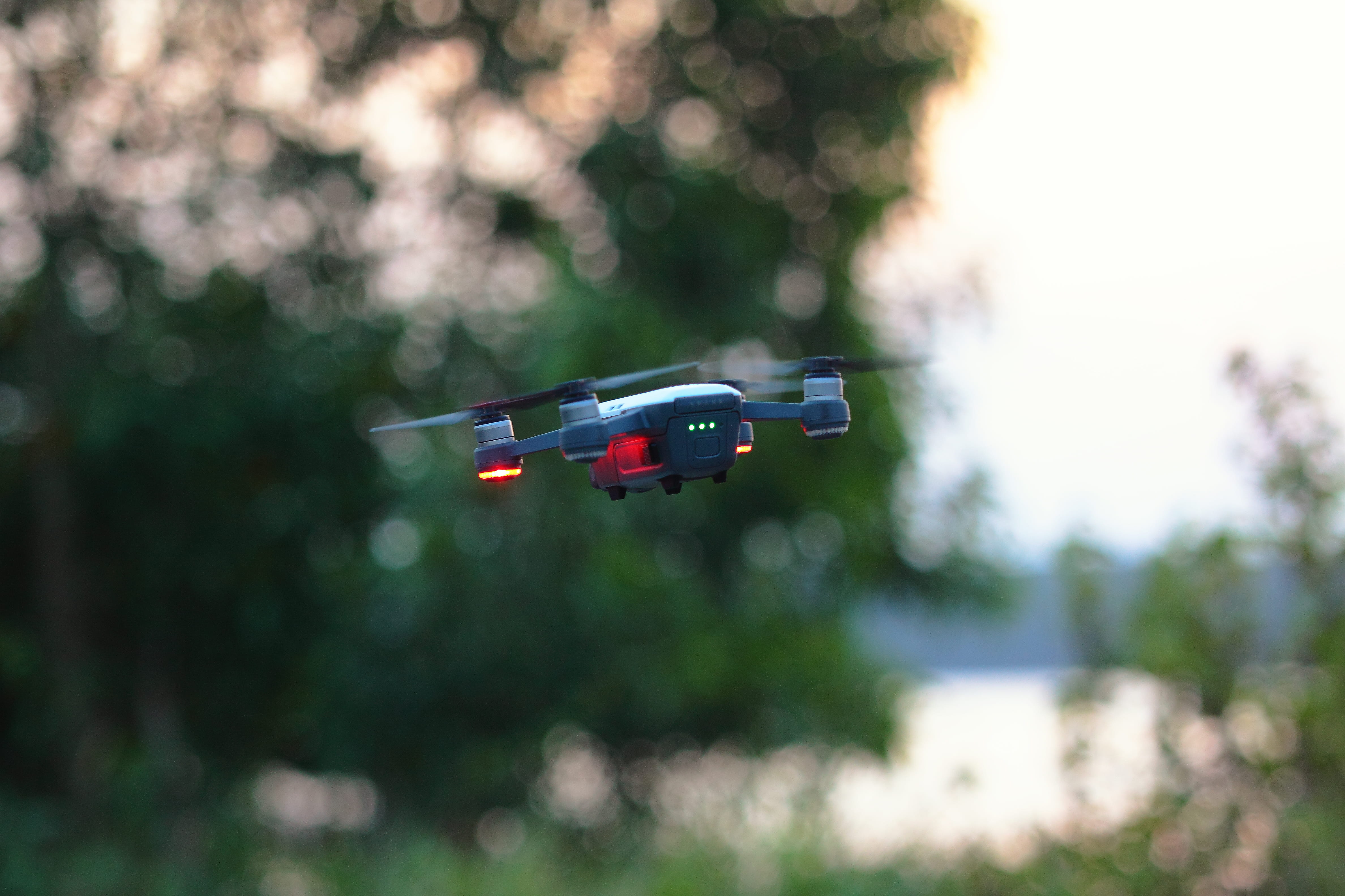 mid-air, mode of transportation, dji, transportation, mavic, blur, red, 4K, outdoors, no people, bokeh, park, trees, plant, daylight, wireless technology, HD Wallpaper