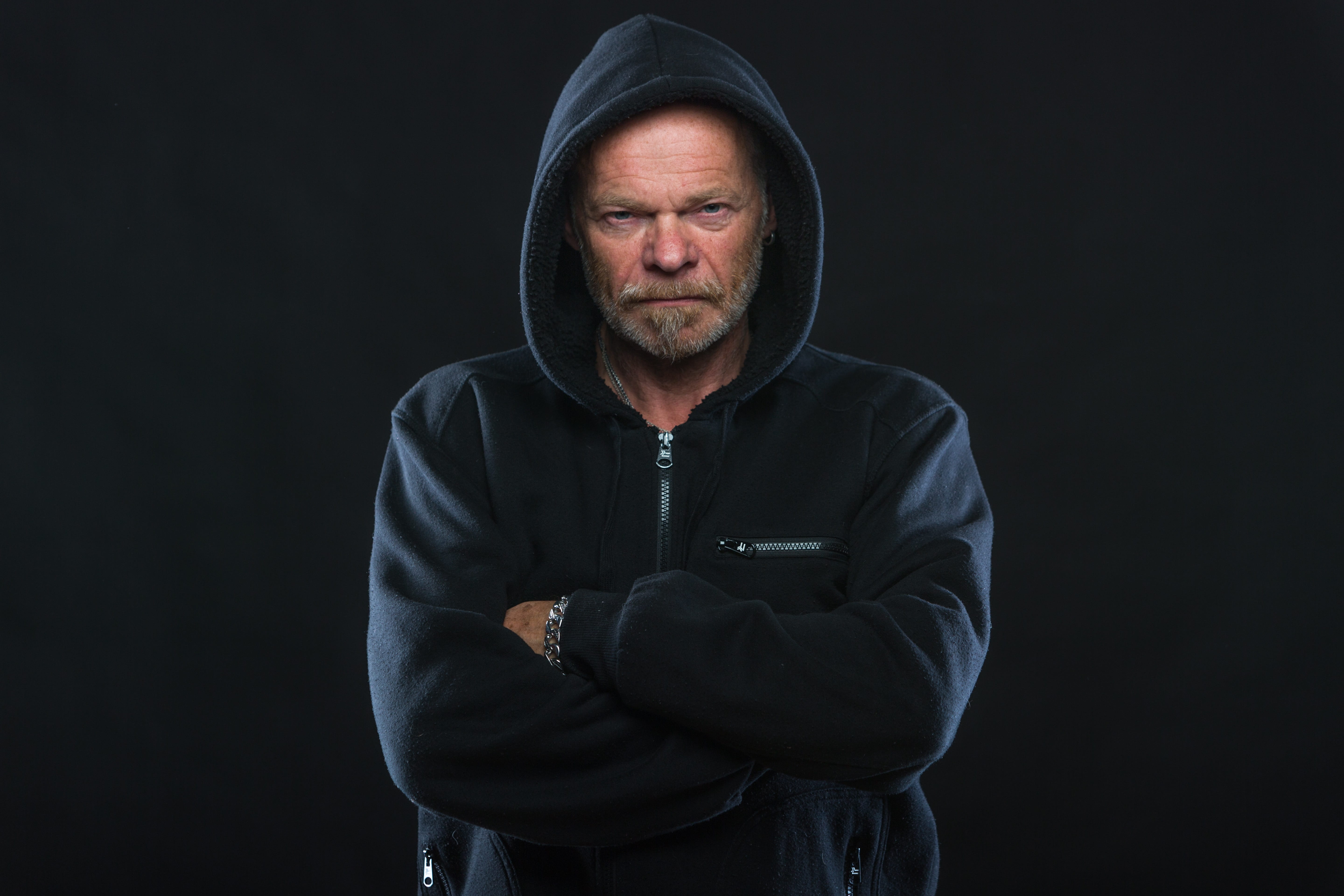 waist up, arms crossed, hood, old, hoodie, bart, indoors, beard, clothing, black background, black, studio shot, mature adult, zip, photo, facial hair, HD Wallpaper