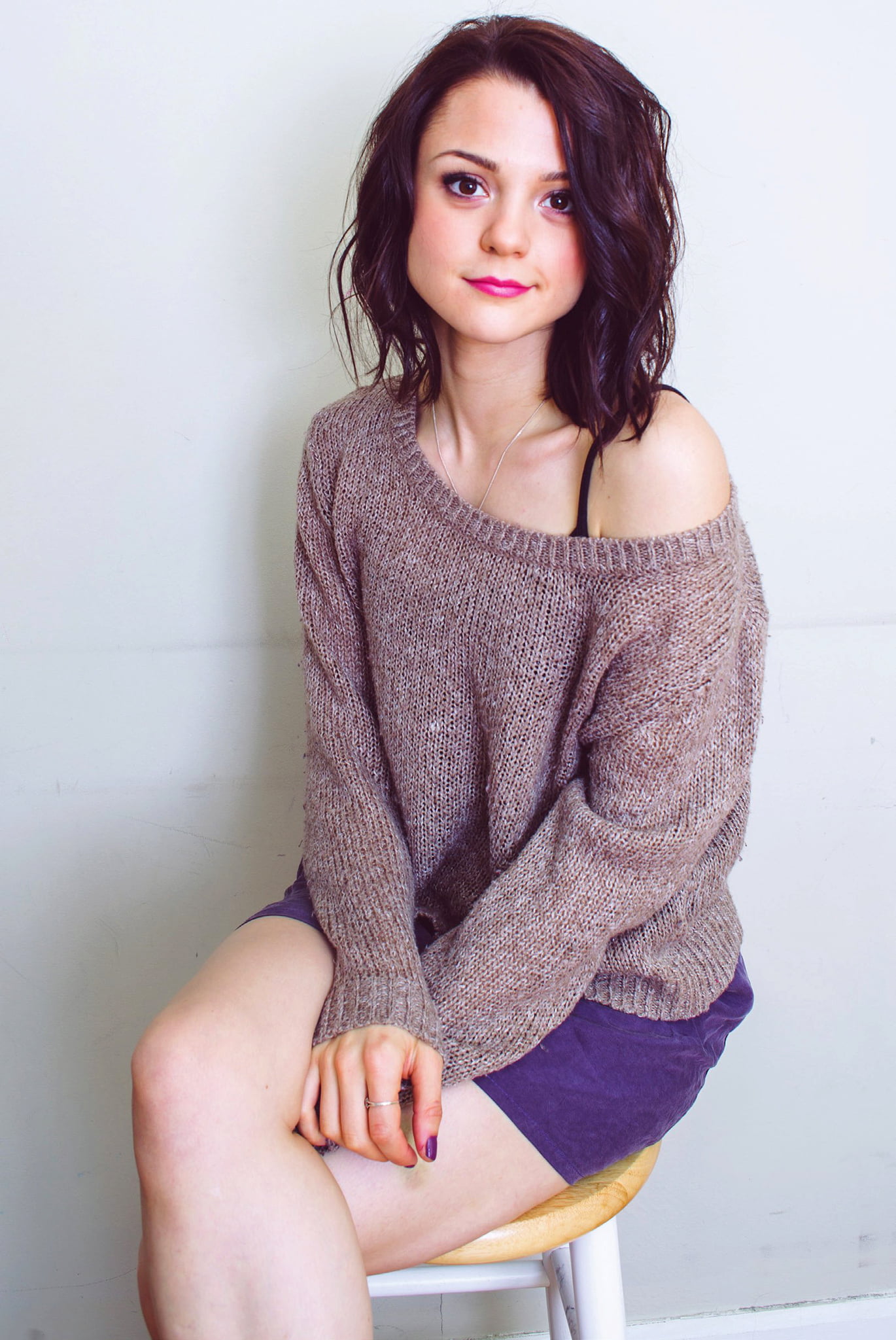 pink lipstick, Kathryn Prescott, simple background, actress, lipstick, women, sitting, shoulder length hair, brunette, 1080P, Phone HD Wallpaper