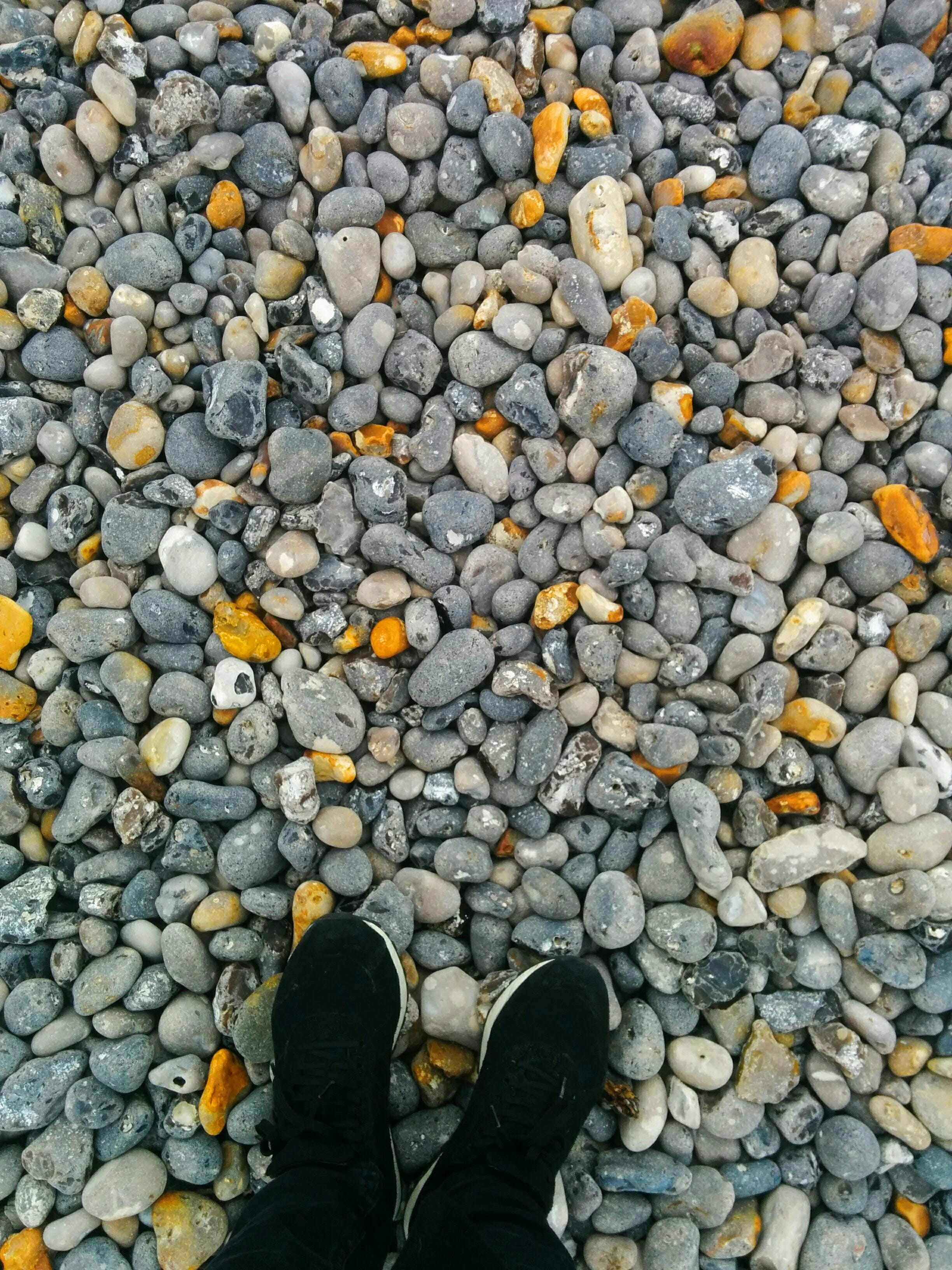 outdoors, unrecognizable person, directly above, lifestyles, rocks, shingle beach, leisure activity, sneaker, day, pebble, dieppe, stone - object, real people, Phone HD Wallpaper