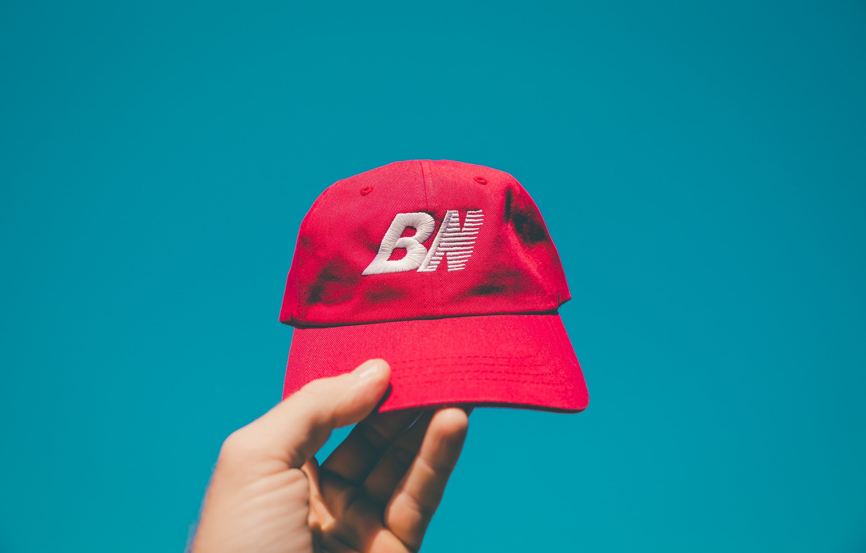 person, low angle shot, holding, body part, blue sky, hat, communication, unrecognizable person, blue background, cap, hand, indoors, single object, 2K, HD Wallpaper