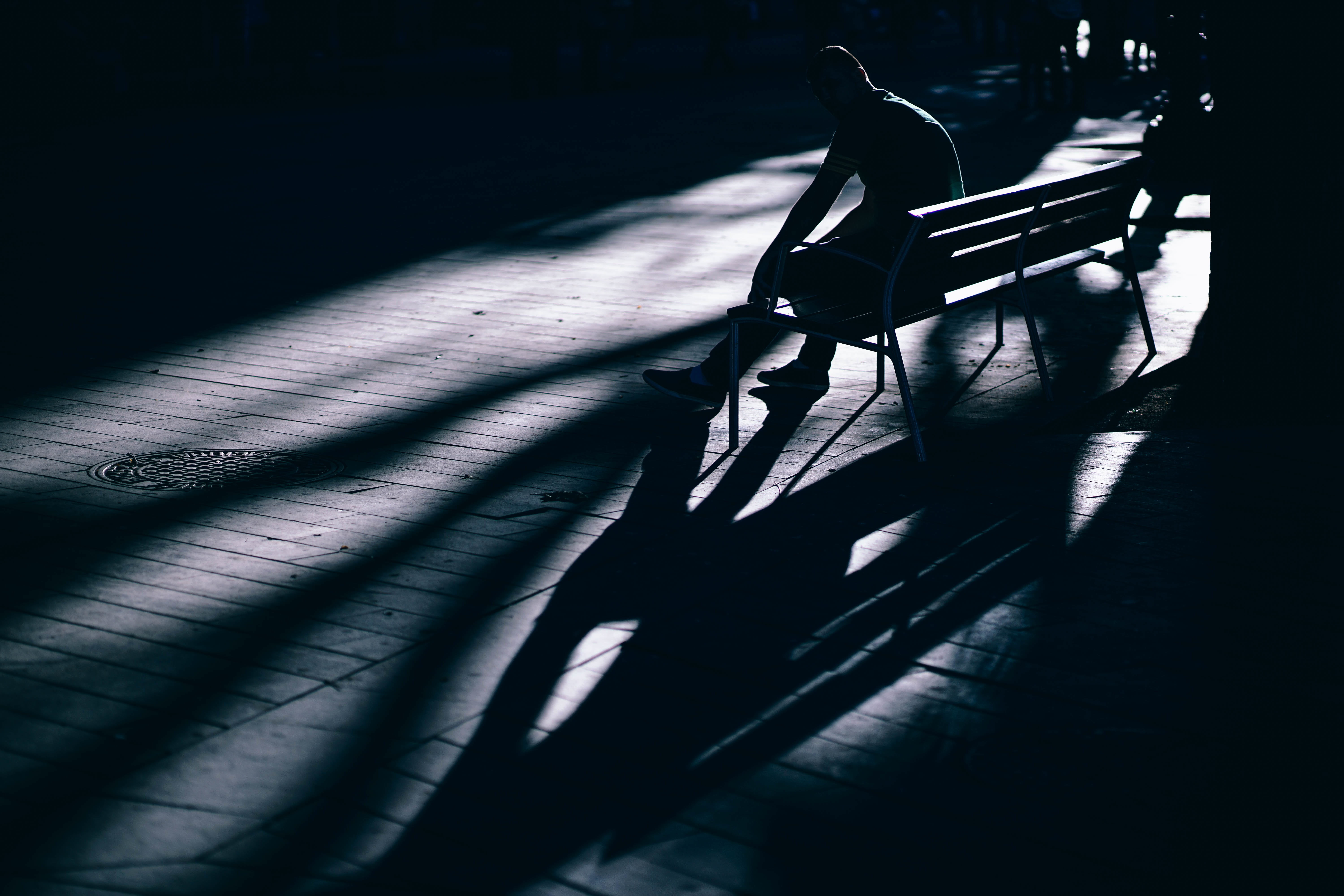 focus on shadow, dark, brown, sitting, man, low, alone, wooden, human leg, photography, close-up, light, indoors, nature, chair, black background, park, HD Wallpaper