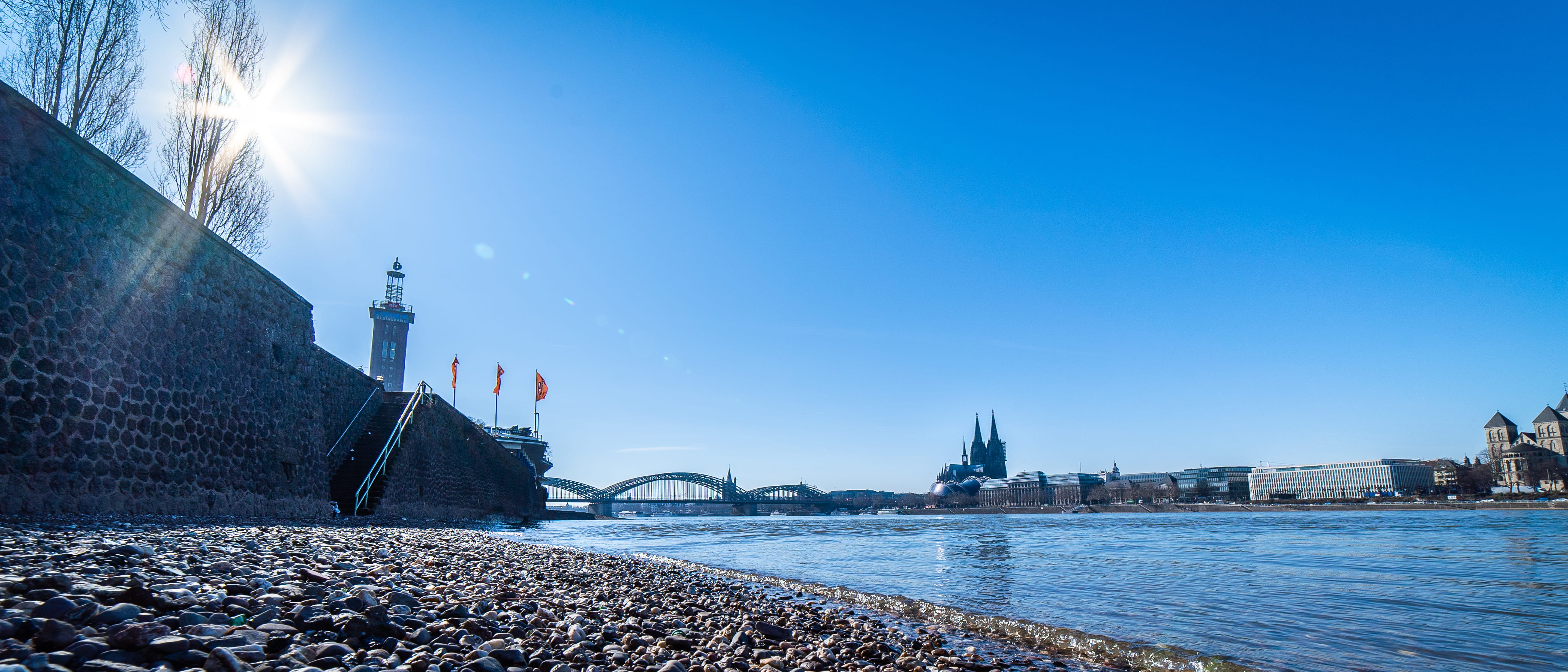architecture, water, waterfront, nature, road, cologne, building, rhine, panorama, river, urban, lens flare, metropolis, hohenzollernbrücke, köln, blue, HD Wallpaper