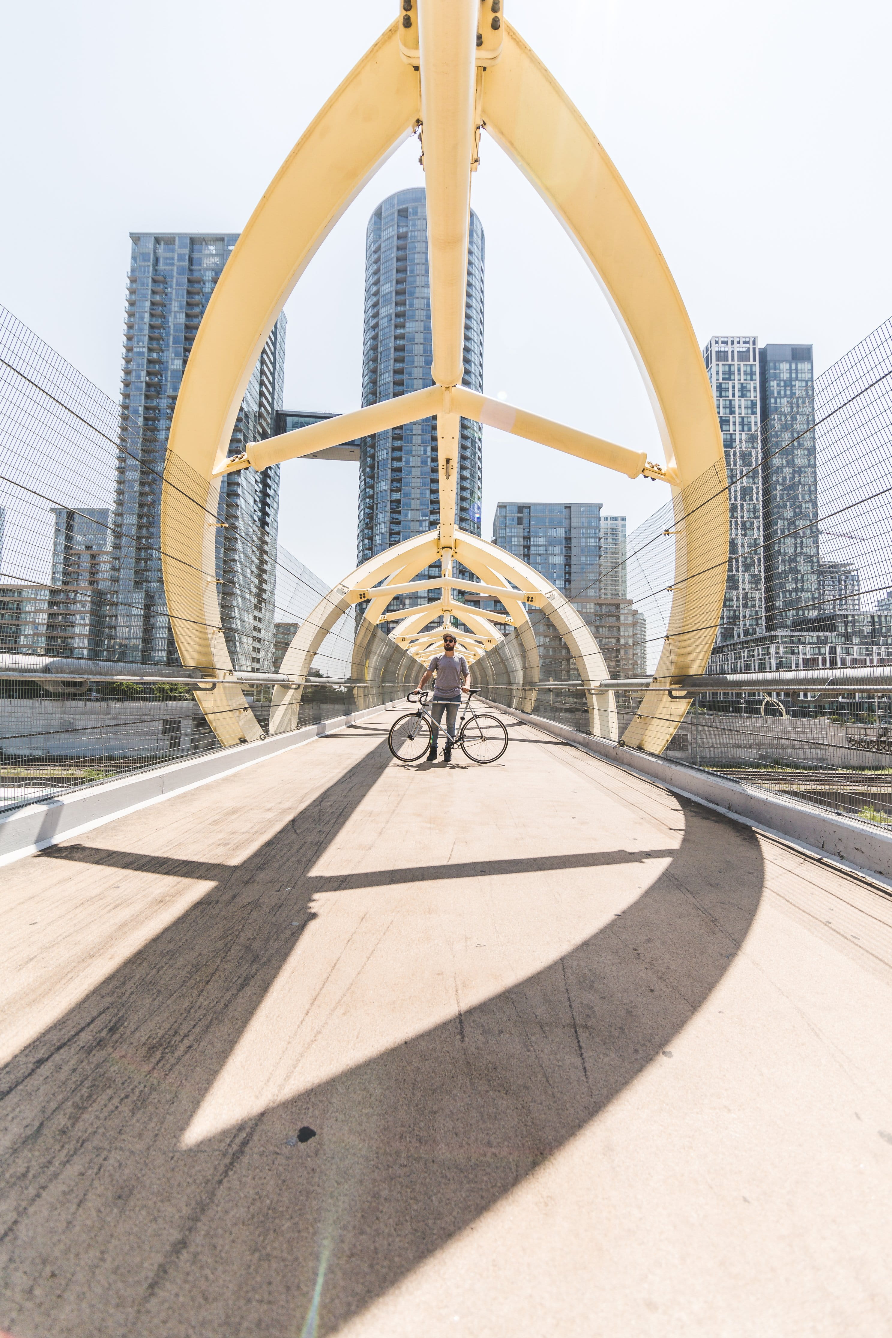 architecture, bridge, outdoors, nature, sky, skyscraper, footpath, shadow, rider, standing, biker, city, cyclist, office building exterior, 4K, bicyclist, Phone HD Wallpaper
