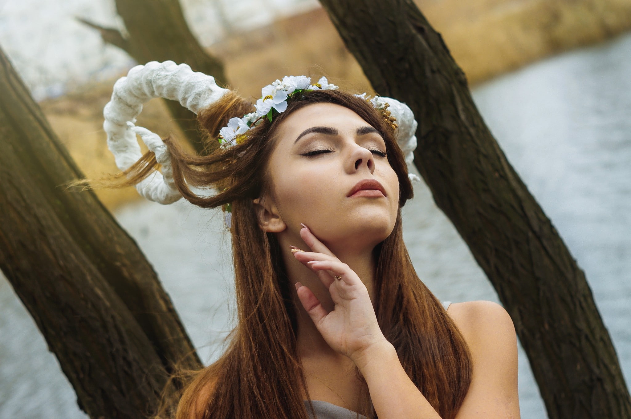 hands, women outdoors, brunette, depth of field, bare shoulders, face, trees, branch, horns, nature, long hair, water, model, closed eyes, flower in hair, HD Wallpaper