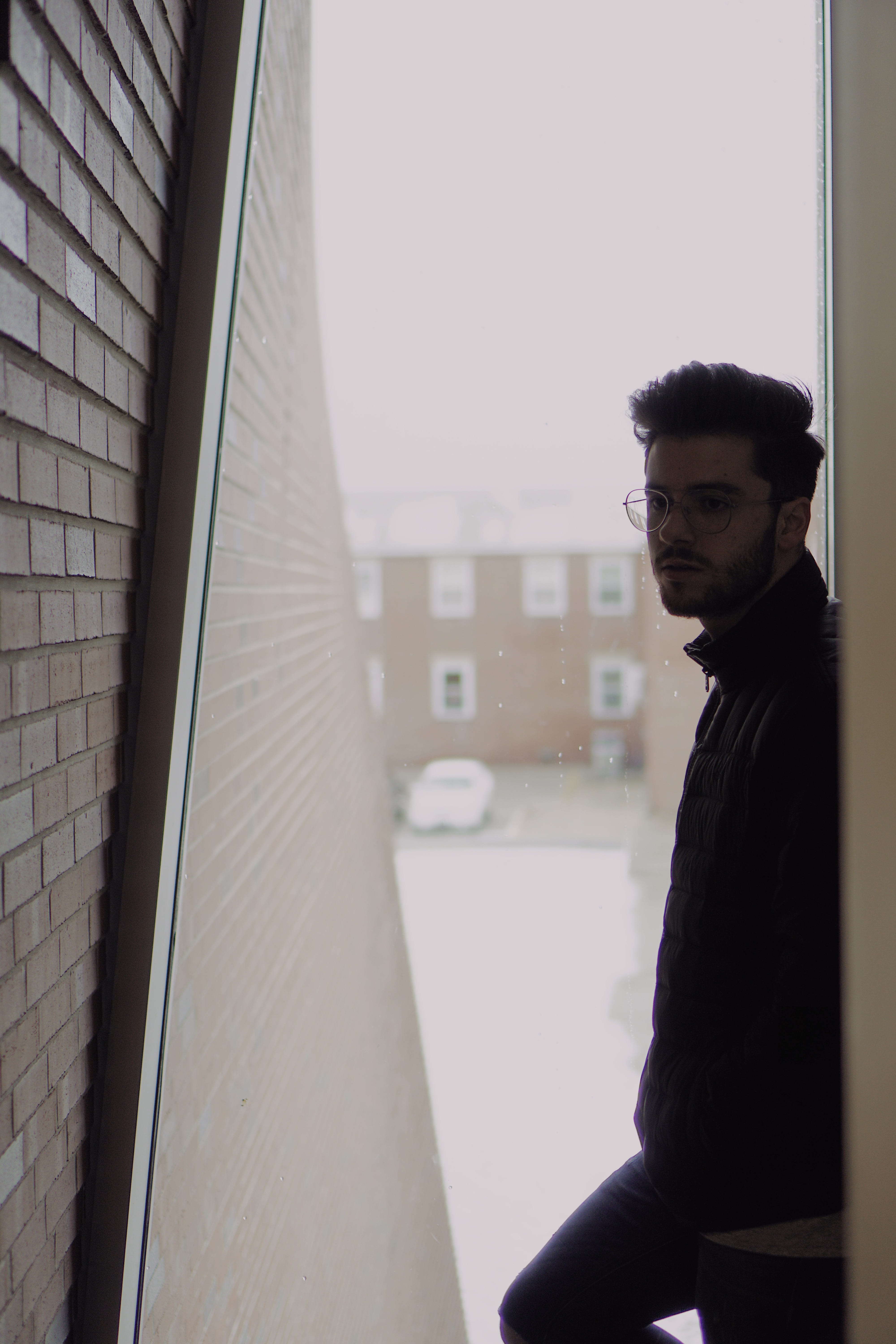 one person, winter, building exterior, man, waist up, black, leaning, jacket, contemplation, day, young men, casual clothing, lifestyles, window, side view, Phone HD Wallpaper