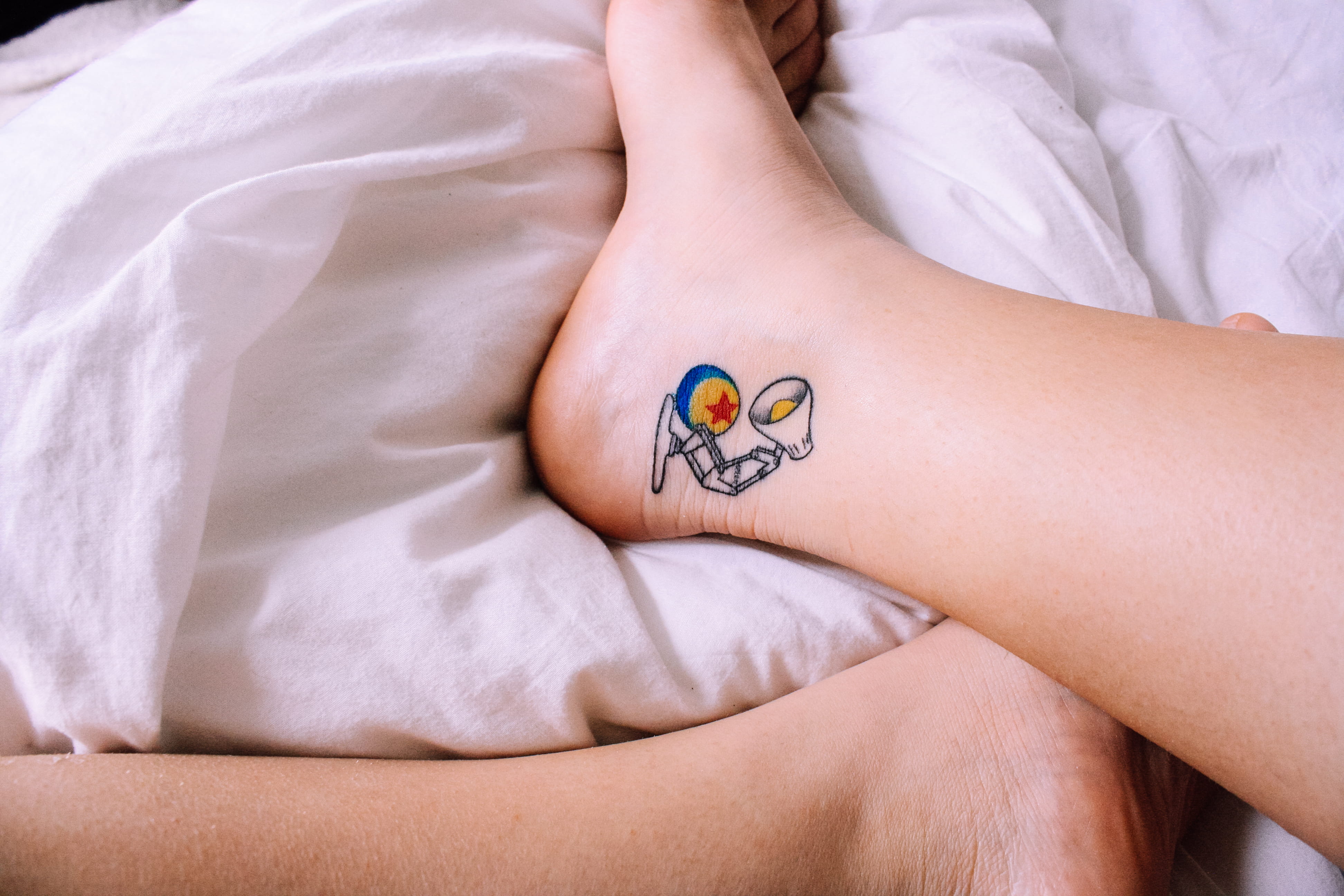 pixar ball, bed, feet, limb, young adult, body part, white, sleeping, lying down, ankle tattoo, pixar, human limb, luxo jr, ball, star, sleep, pixar lamp, HD Wallpaper