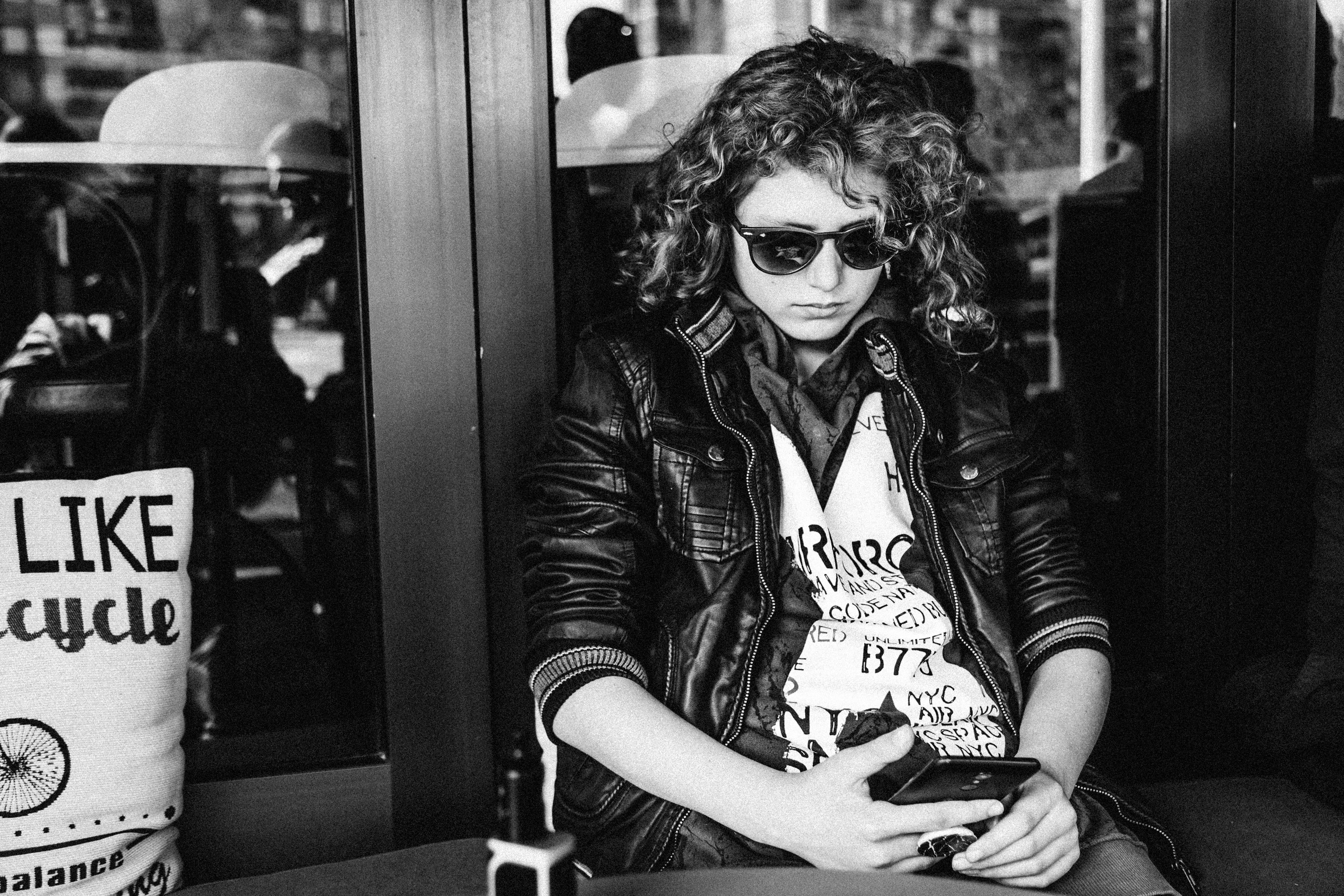 looking at phone, greyscale, train - vehicle, hairstyle, cool, black and white, phone, monochrome, person, woman, boy, 5K, black, portrait, jacket, clothing, HD Wallpaper