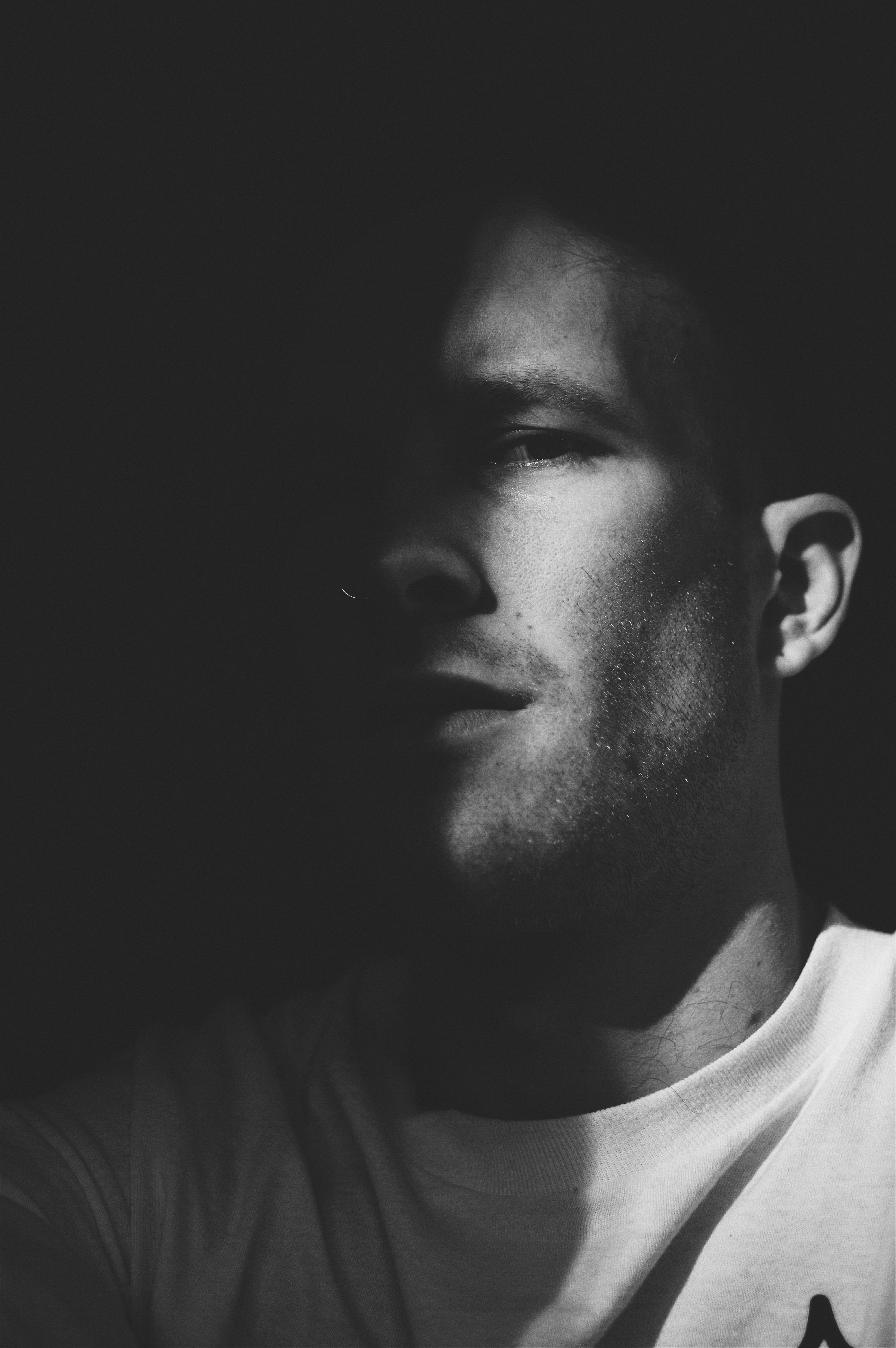 one person, fine-looking, portrait, black and white, wearing, t, photoshoot, shirt, young men, black-and-white, black background, facial hair, close-up, Phone HD Wallpaper